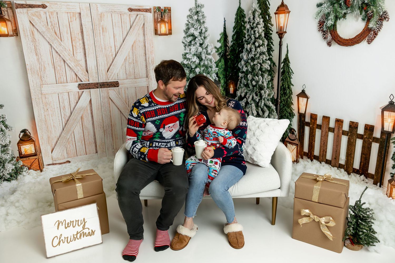 Holiday portrait on white couch with Christmas decorations and wrapped presents.