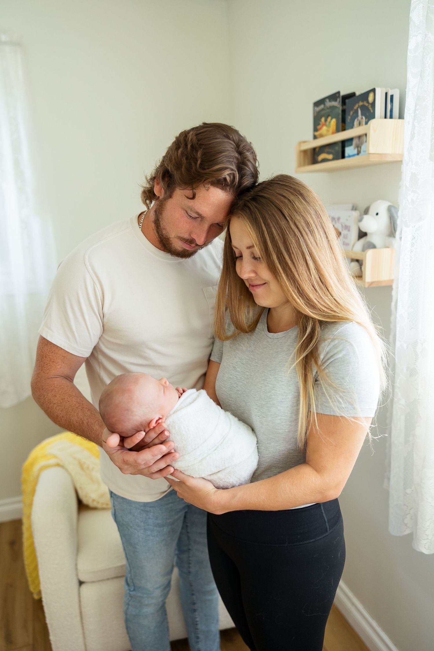 A series of intimate lifestyle photos showing tender moments with a newborn baby in a bright, airy home setting.