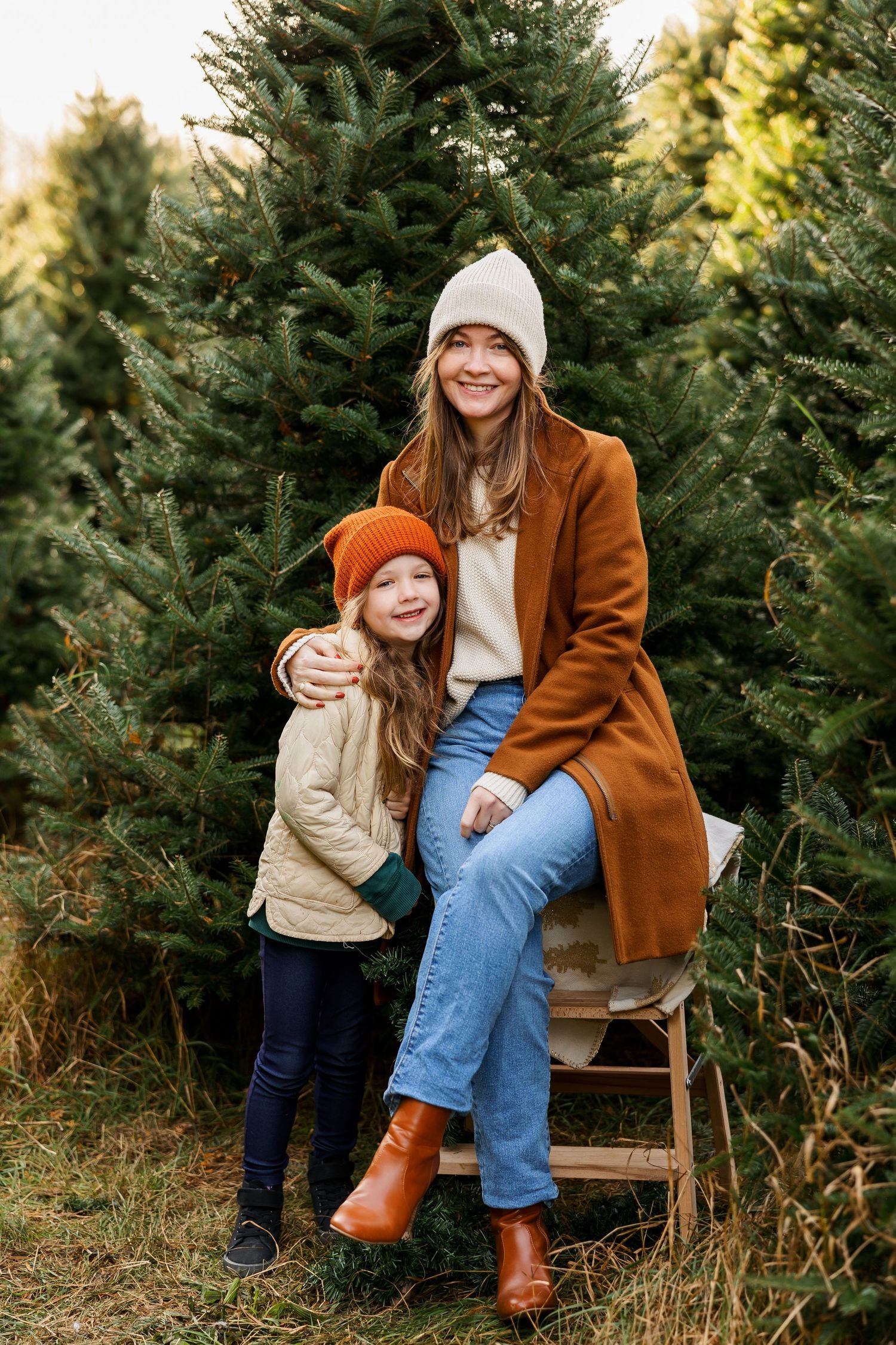 Heartwarming autumn scene with parent and child sharing tender moments among evergreen trees at a Christmas tree farm.