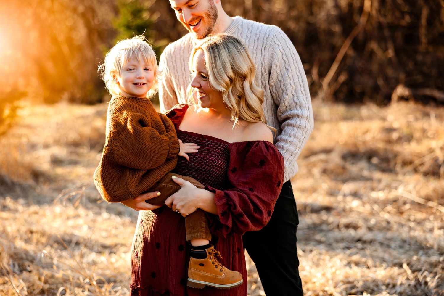 Joyful family moment captured in golden sunlight during outdoor photo session.