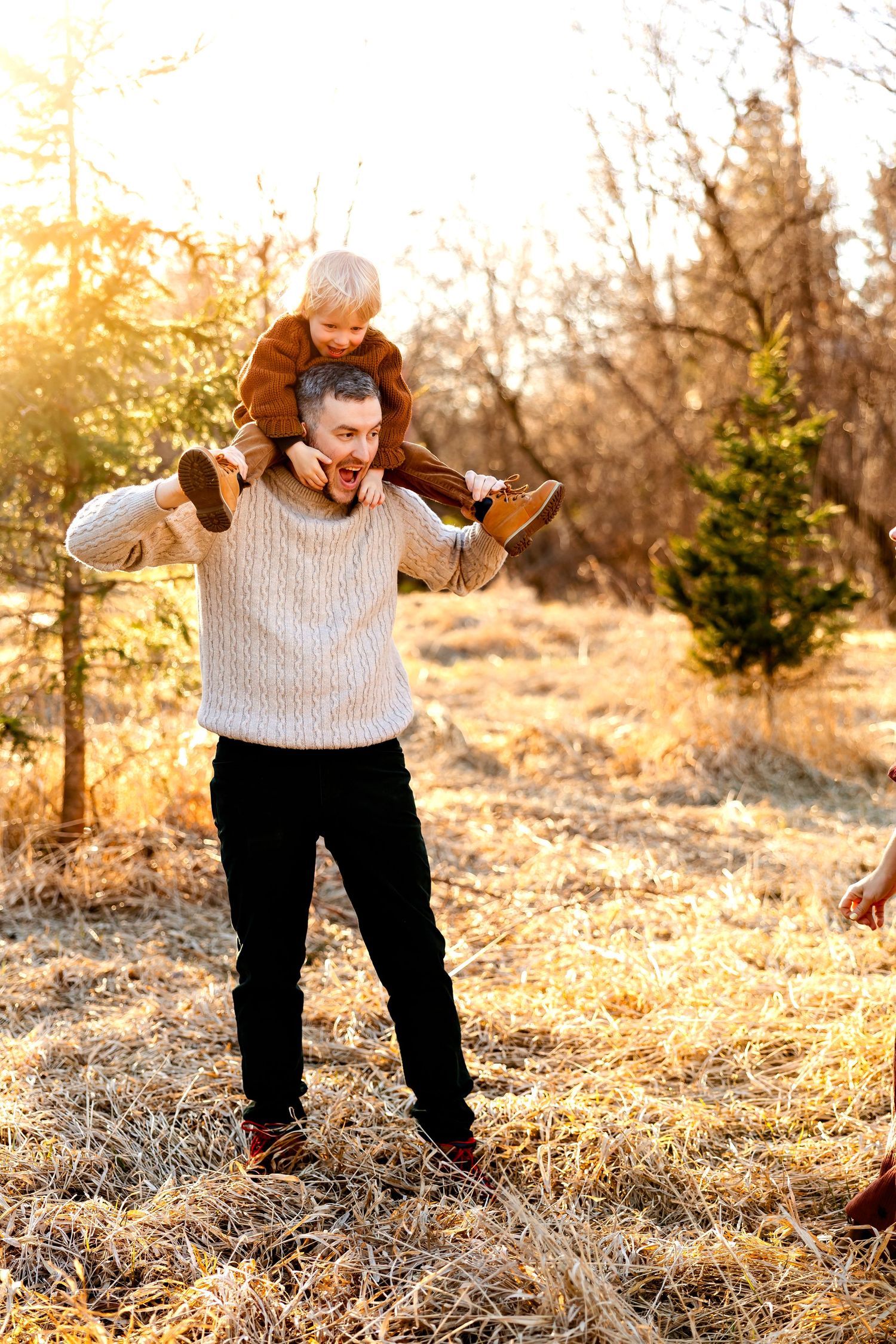 Playful shoulder ride moment during a family photoshoot in autumn setting.