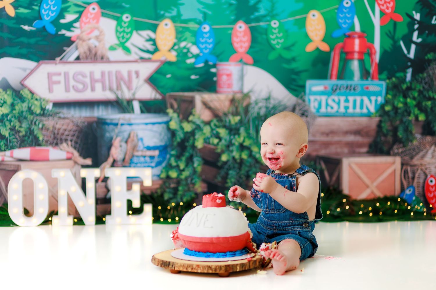 Fishing-themed first birthday setup with nautical decorations and fishing-themed cake.