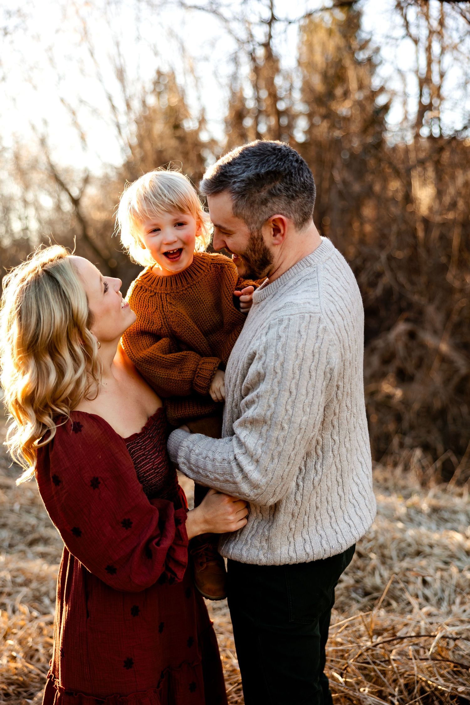 A candid family moment filled with laughter during a sunset photoshoot.