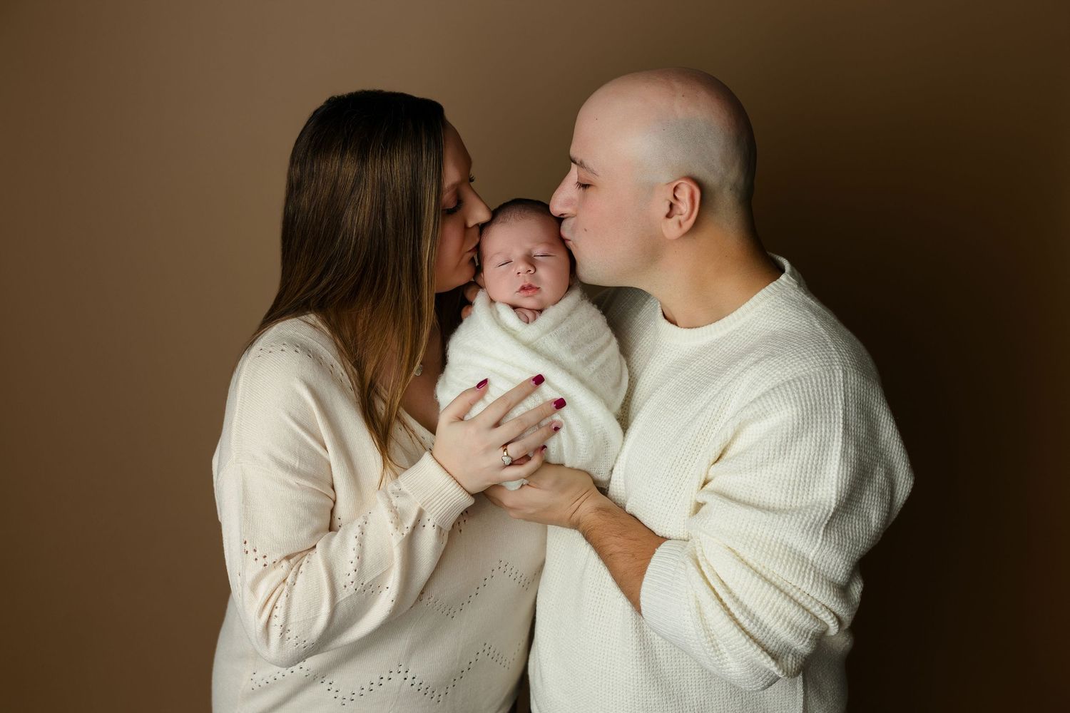 Two people in white sweaters share tender embraces and loving moments in a romantic photoshoot series.