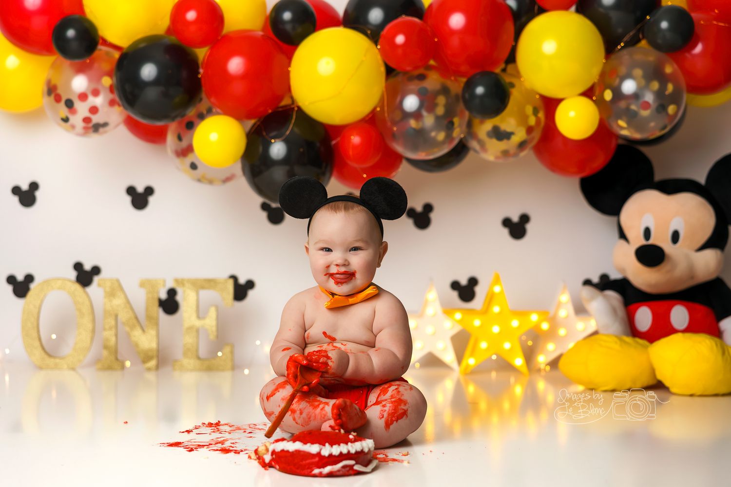 Mickey Mouse themed birthday party with red, yellow and black balloon arch.