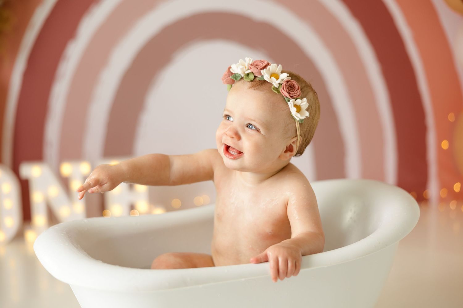 Vintage-style bath tub portrait with circular rainbow background and balloon decorations.