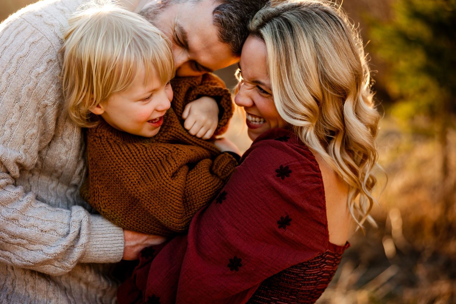 An intimate family embrace filled with joy and laughter at sunset.