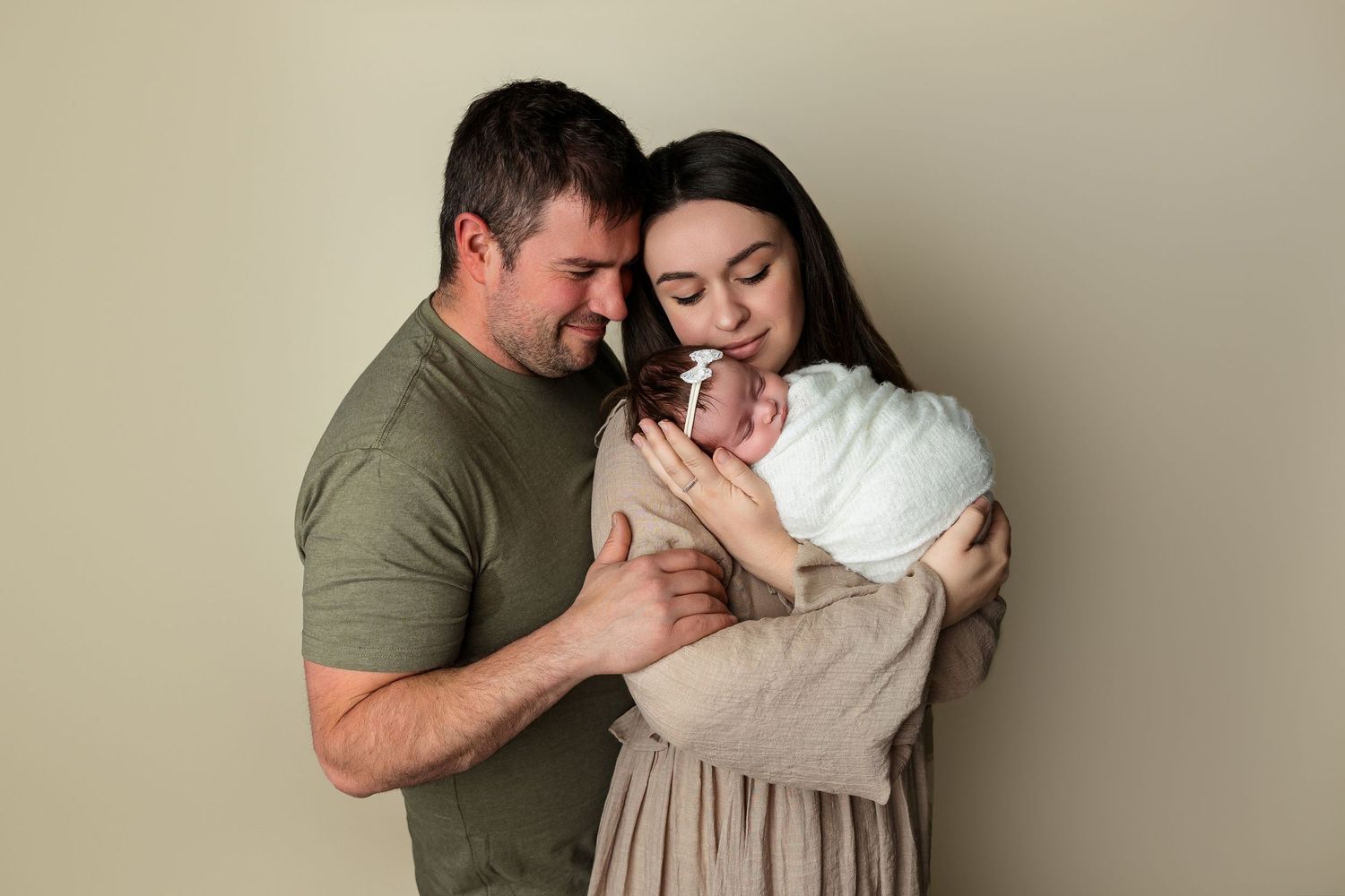 Family holding newborn in light-filled Brantford studio