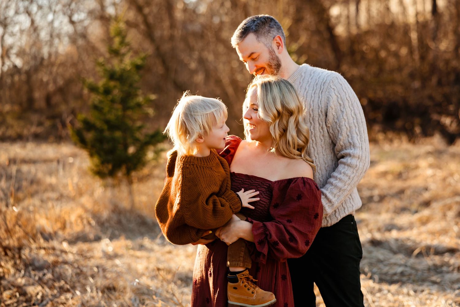 Loving family portrait against autumn backdrop with natural lighting.