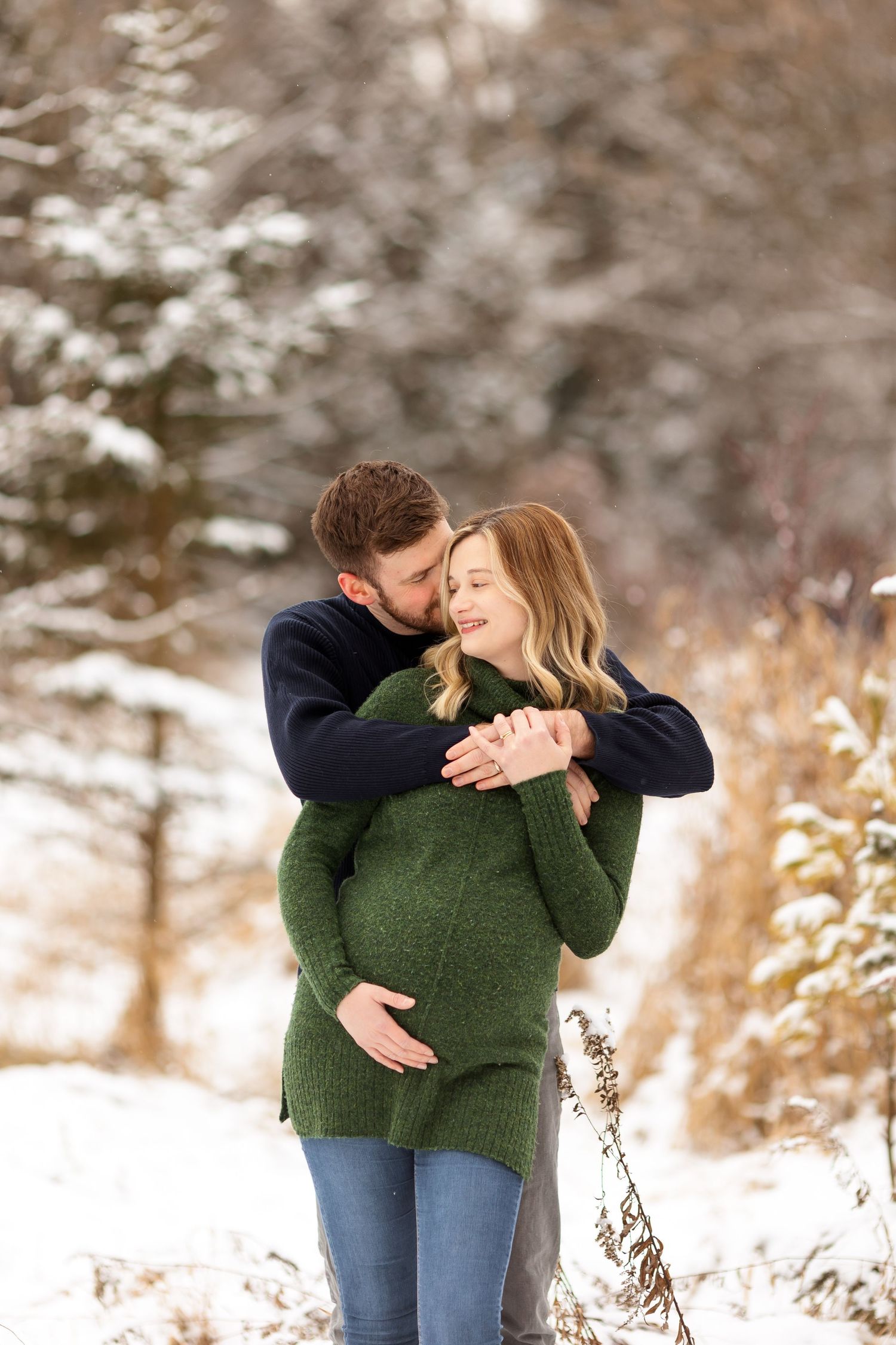 An intimate embrace captured during a snowy winter maternity session.
