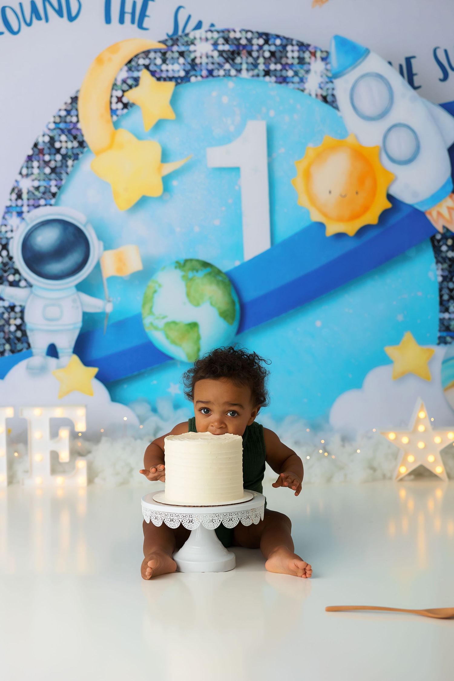 Space themed first birthday setup with cake and celestial decorations.