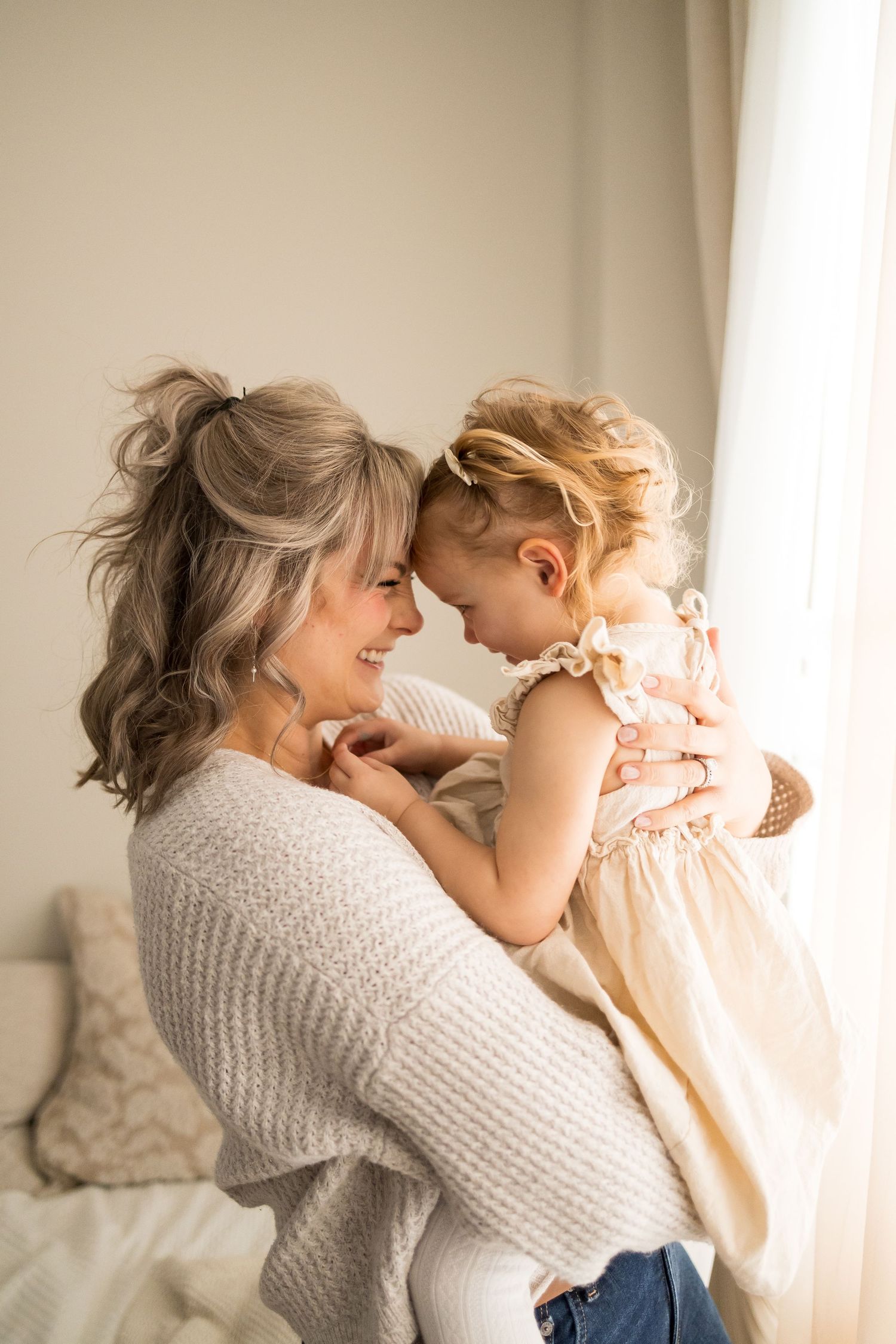 Sweet candid moments between parent and child in soft natural light wearing cozy knit sweaters.