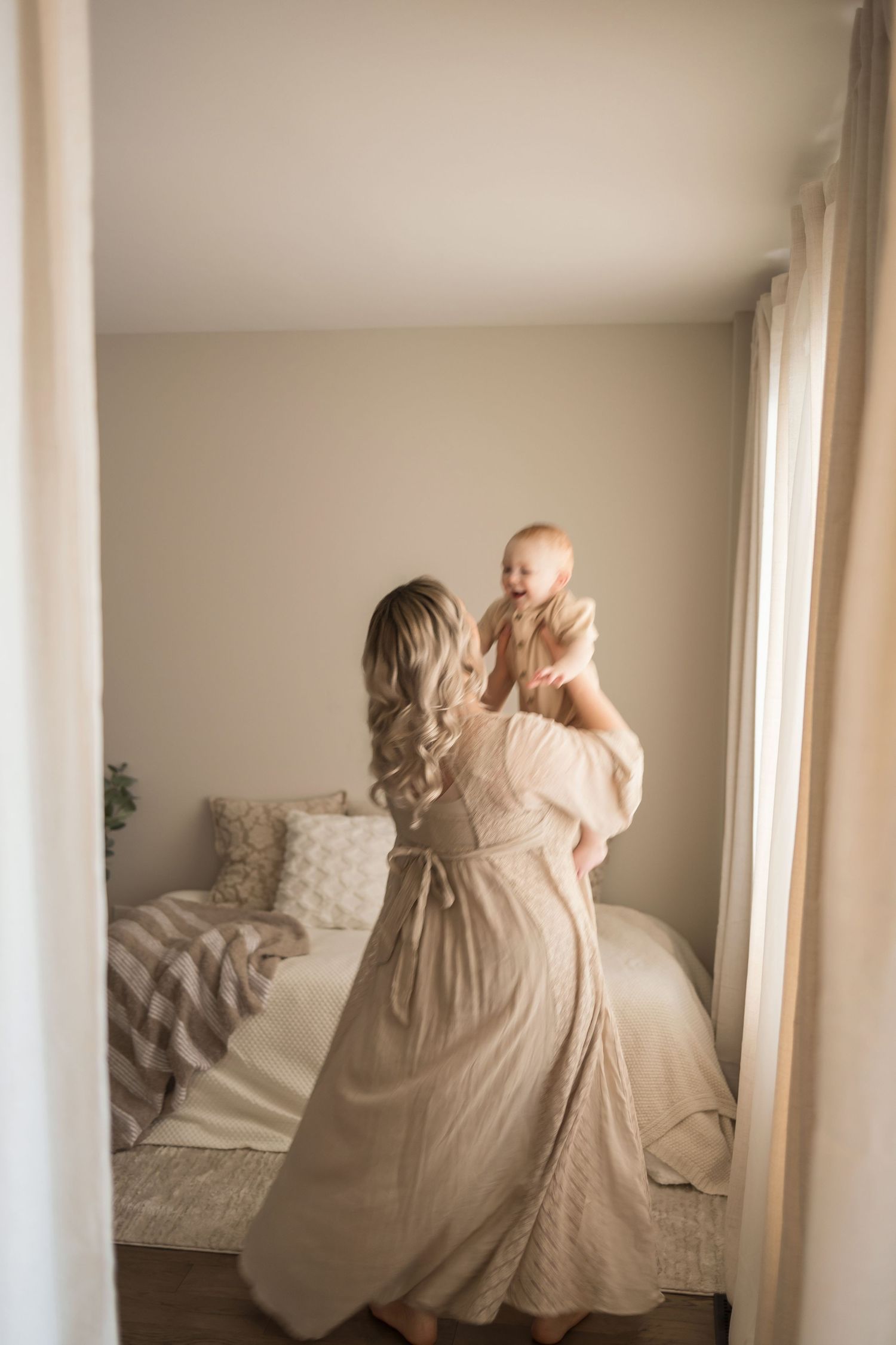 A series of three ethereal photos showing a person in a flowing cream dress twirling against white walls and natural light.