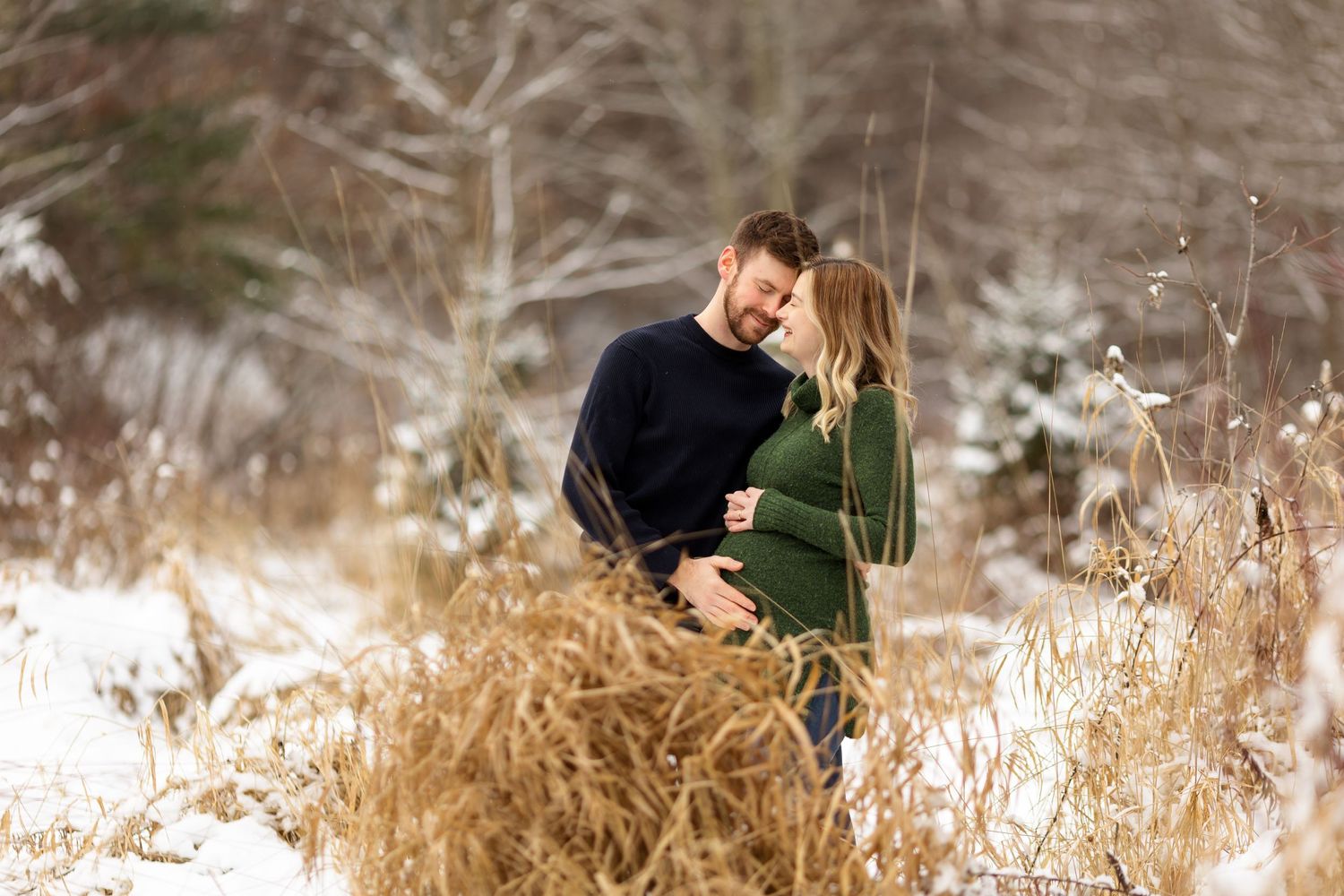 Intimate winter portrait session with snow and dried grass in background.