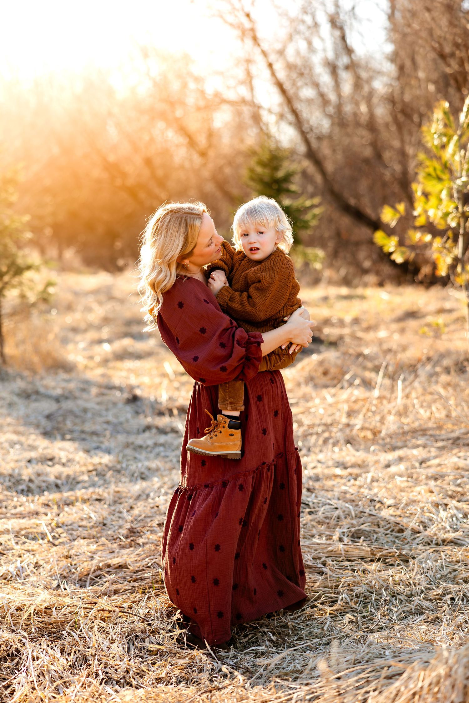 A tender moment between parent and child captured in glowing sunset light.