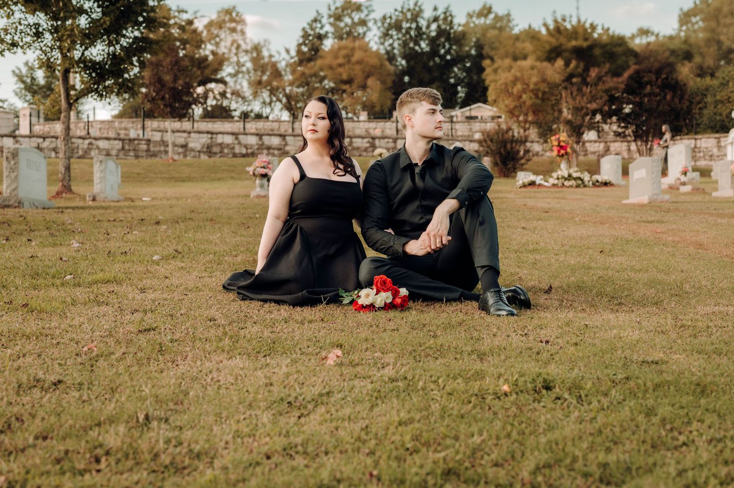 People relax and picnic on a grassy hill during a warm autumn day in a park.