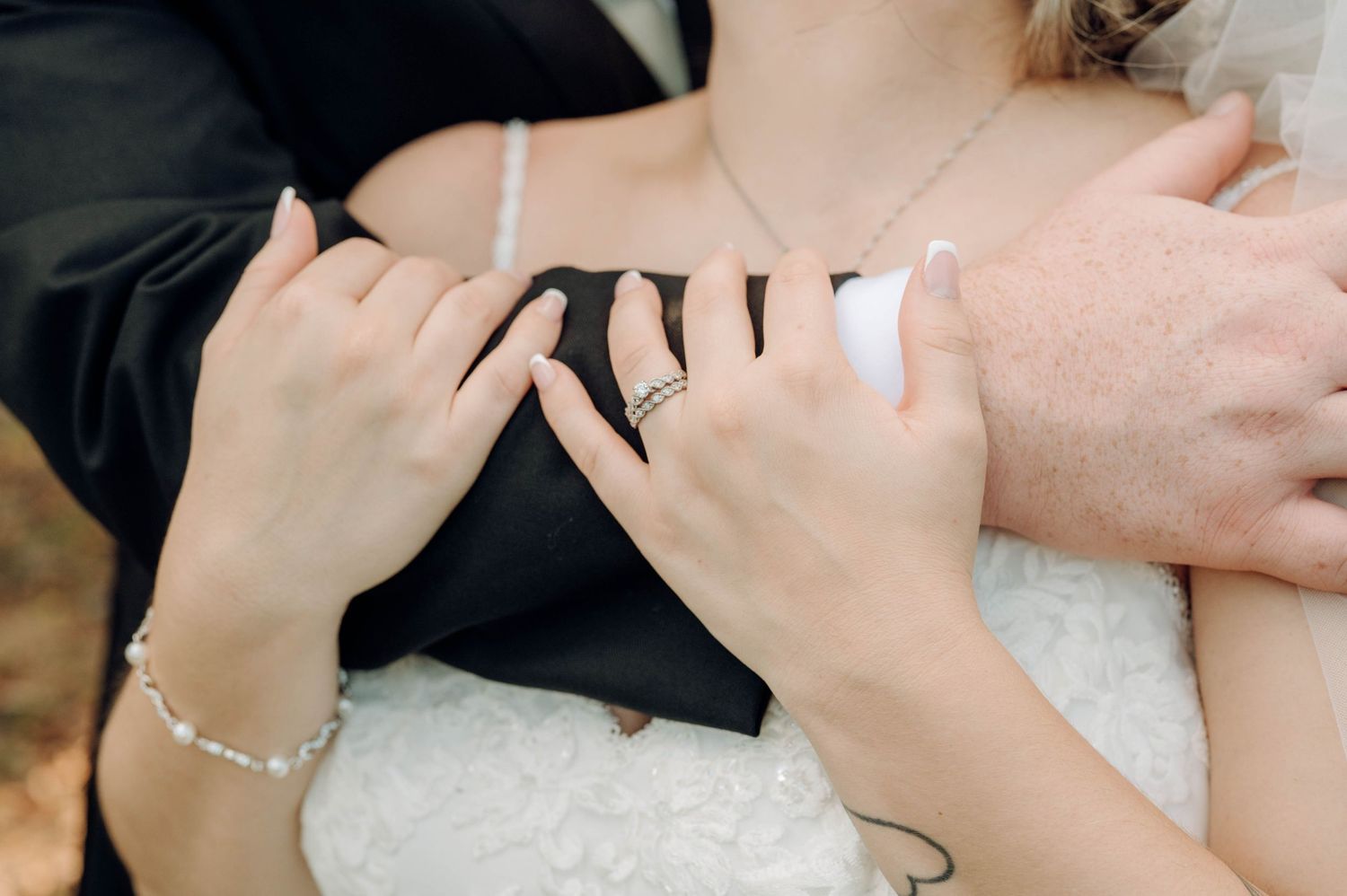 Close-up view of hands exchanging wedding rings during a traditional marriage ceremony.