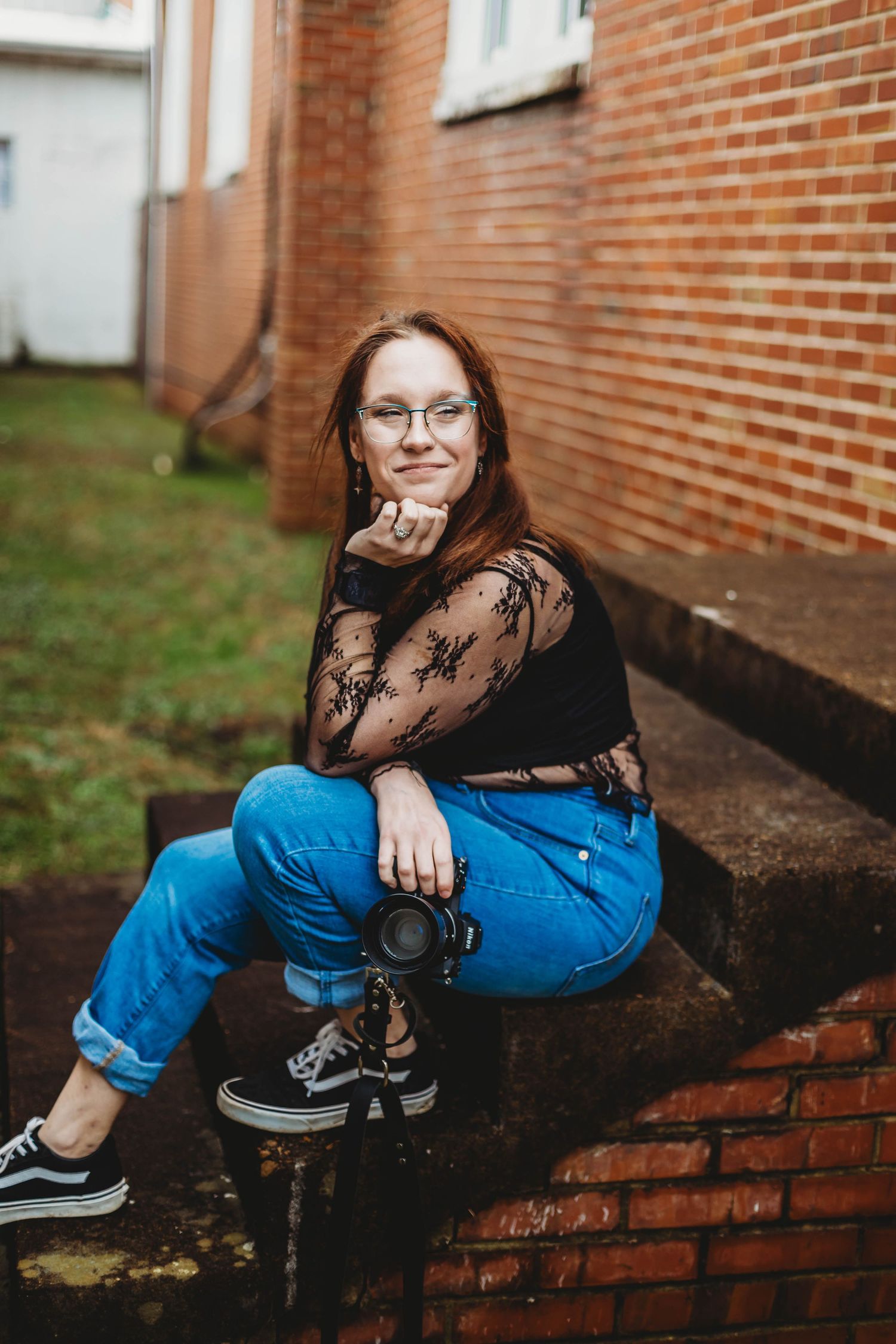A casual photography session on brick steps featuring camera equipment and urban styling.