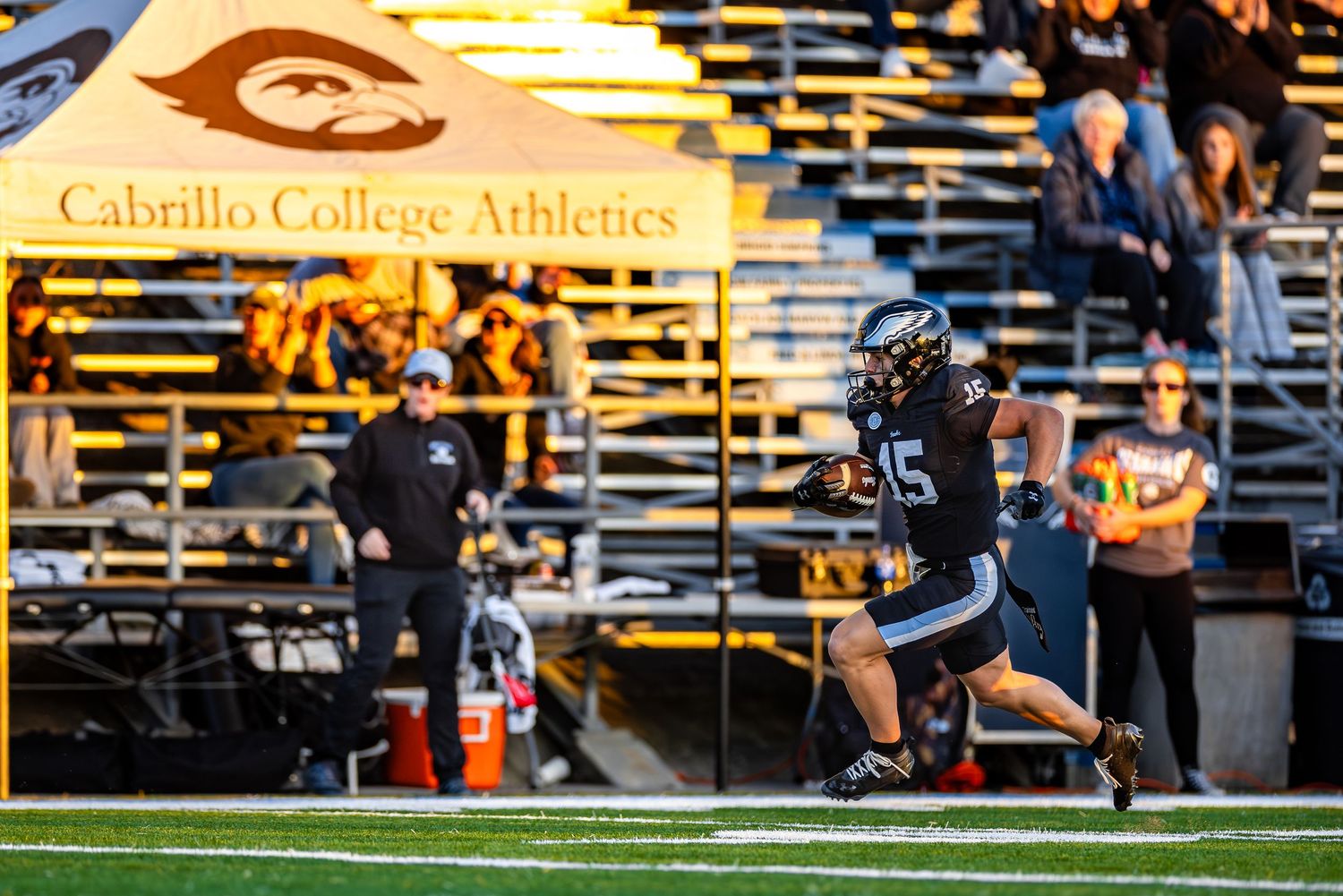 College football players compete in an intense game under stadium lights during a night match.