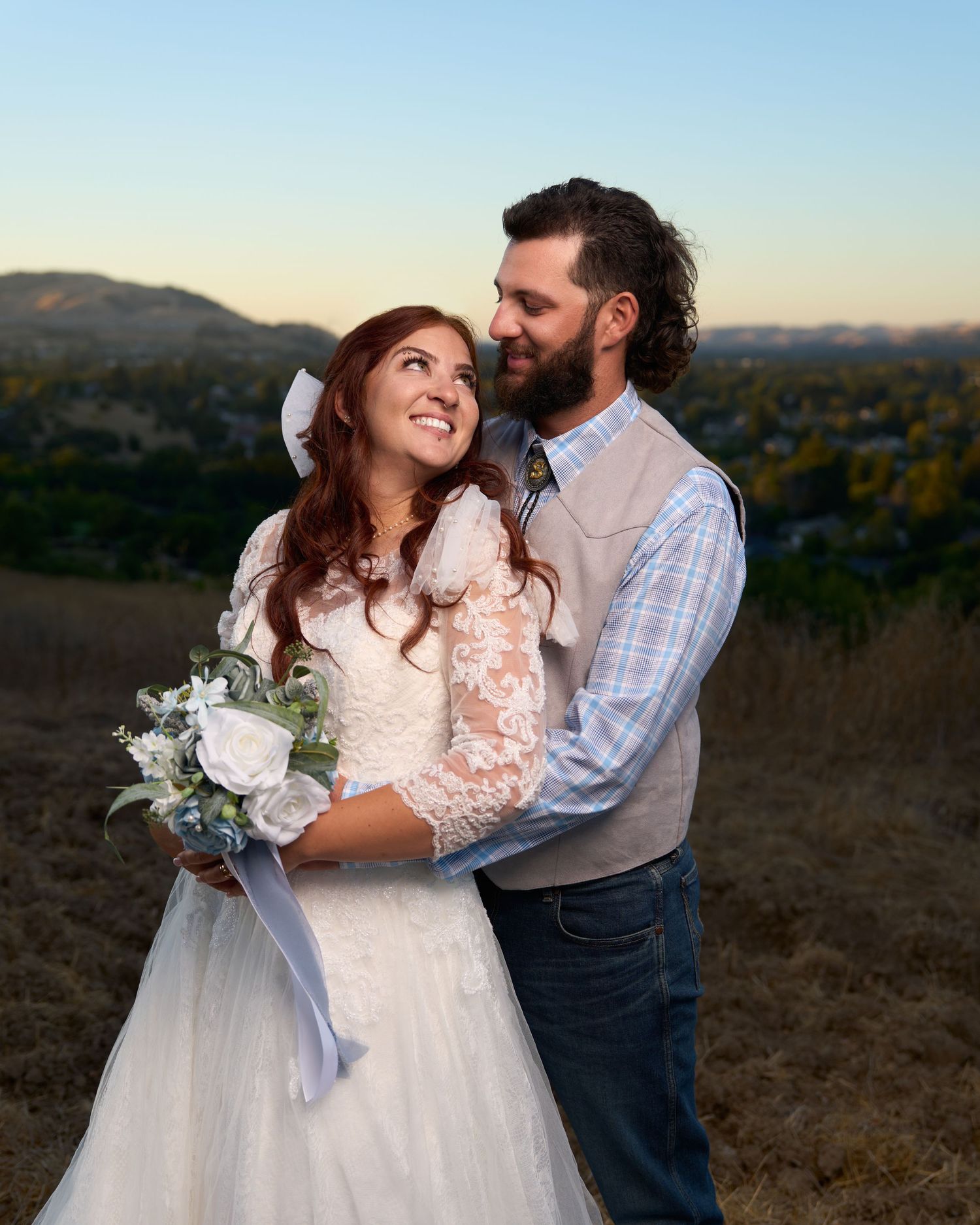 A wedding couple smiling lovingly at each other.
