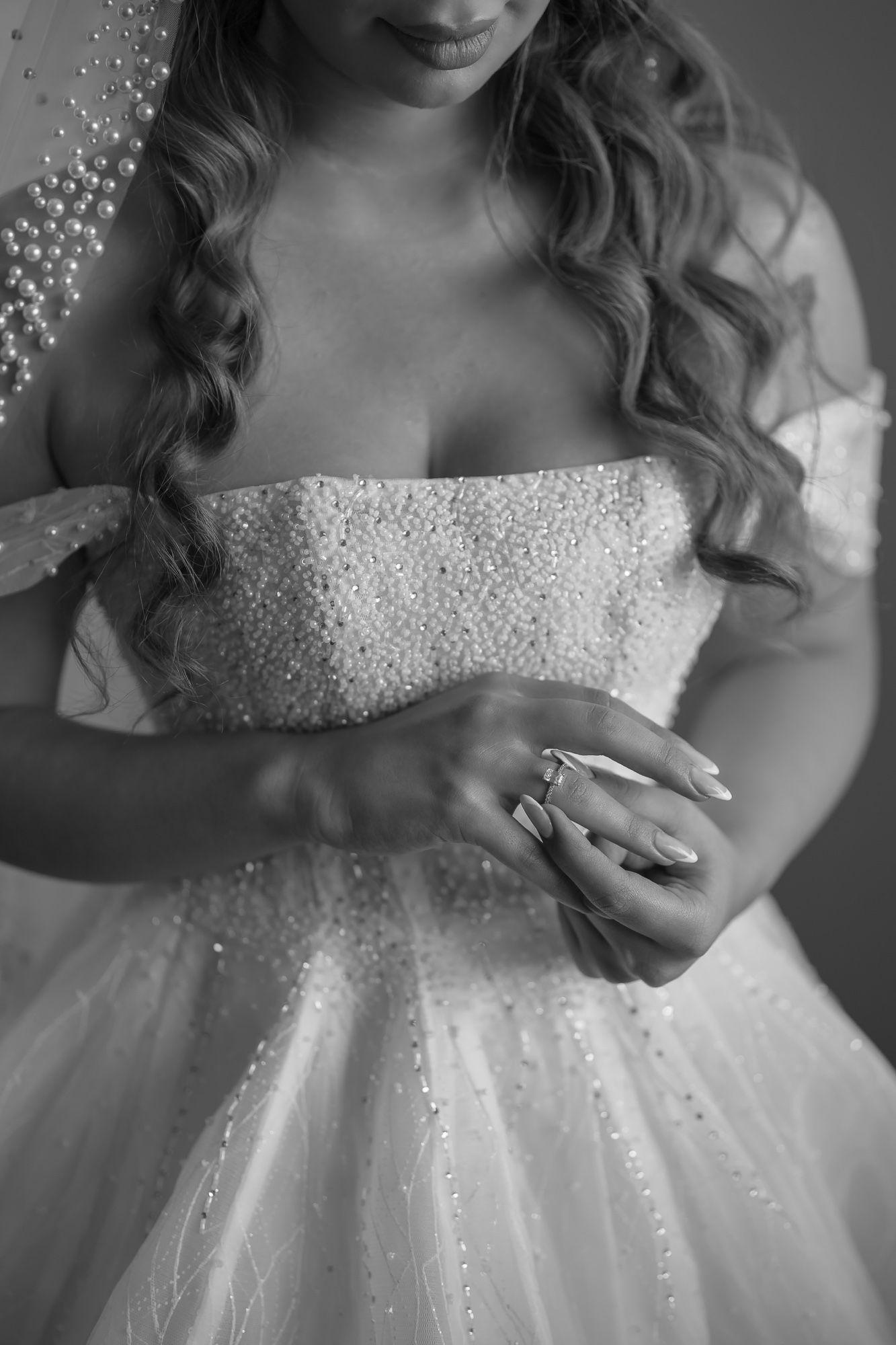 Close up details of a sparkly white wedding dress bodice with beaded embellishments.