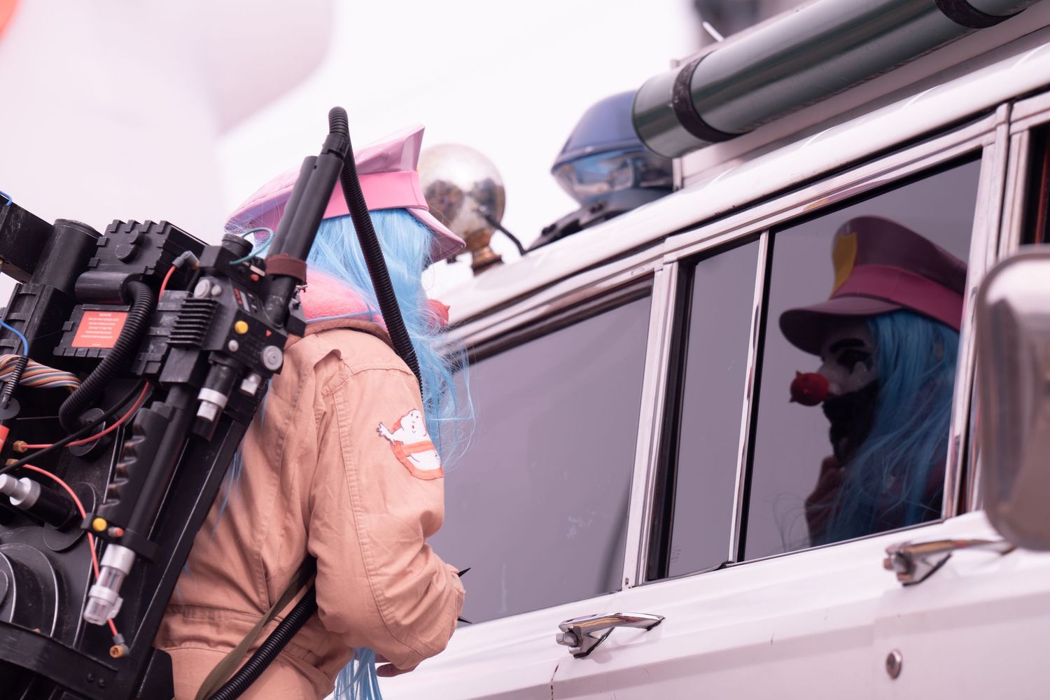 An event guest at Nain Rough parade in Detroit adjusts his Ghostbusters costume while looking at his reflection in a car window.