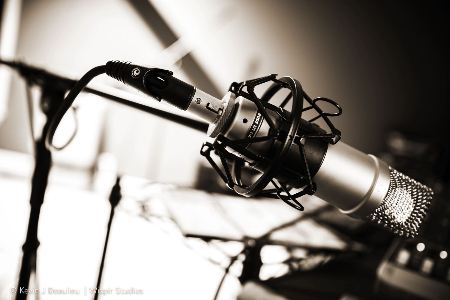 Close-up of a professional condenser microphone on a stand in a recording studio, black and white photography.