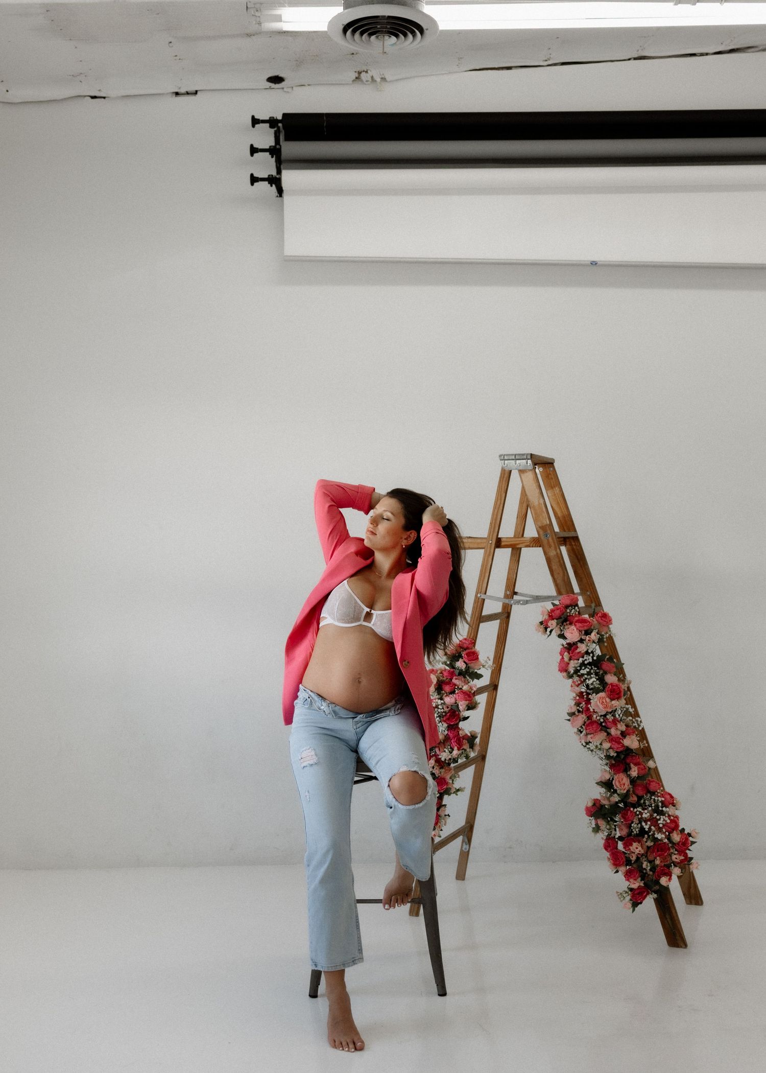 A photo composite showing a person in jeans and pink top arranging flowers on an easel in multiple sequential poses.