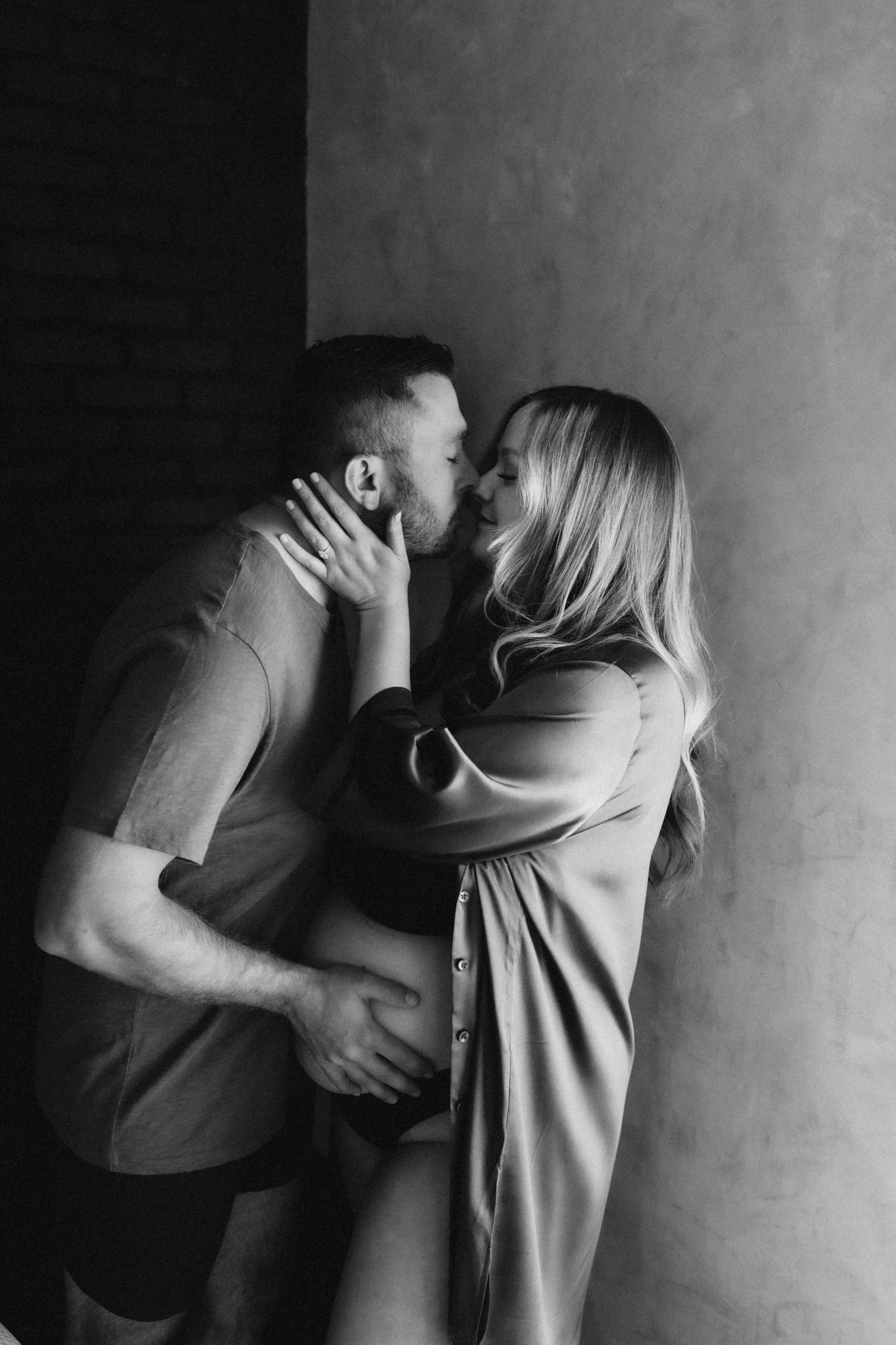 Intimate black and white photo of romantic couple sharing a passionate moment.