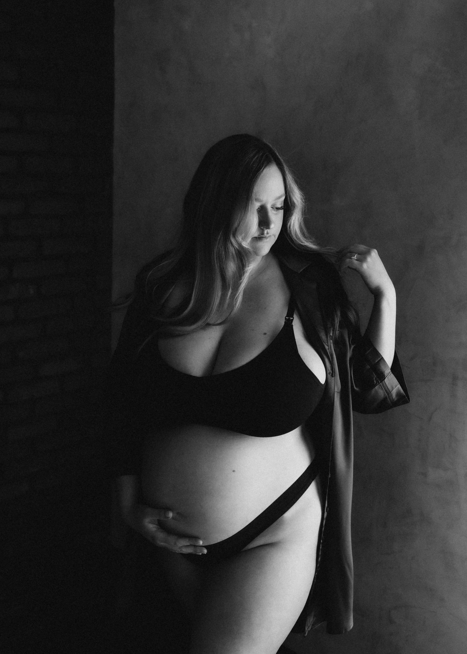 Black and white maternity boudoir photo with soft natural light.