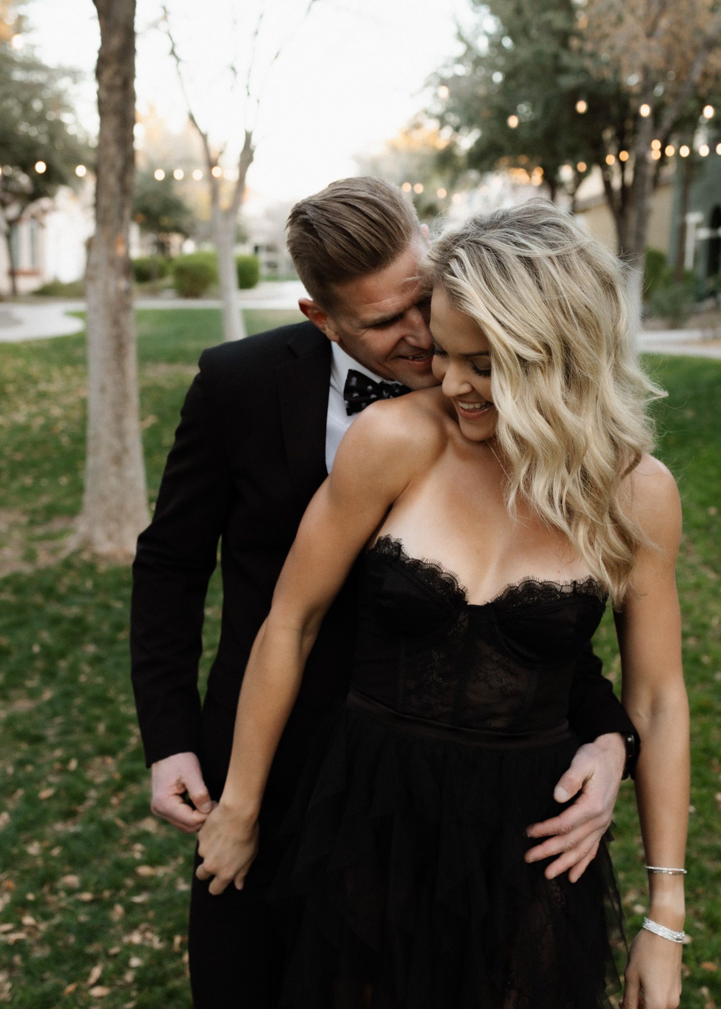 Intimate evening garden portrait featuring couple in black formal attire.