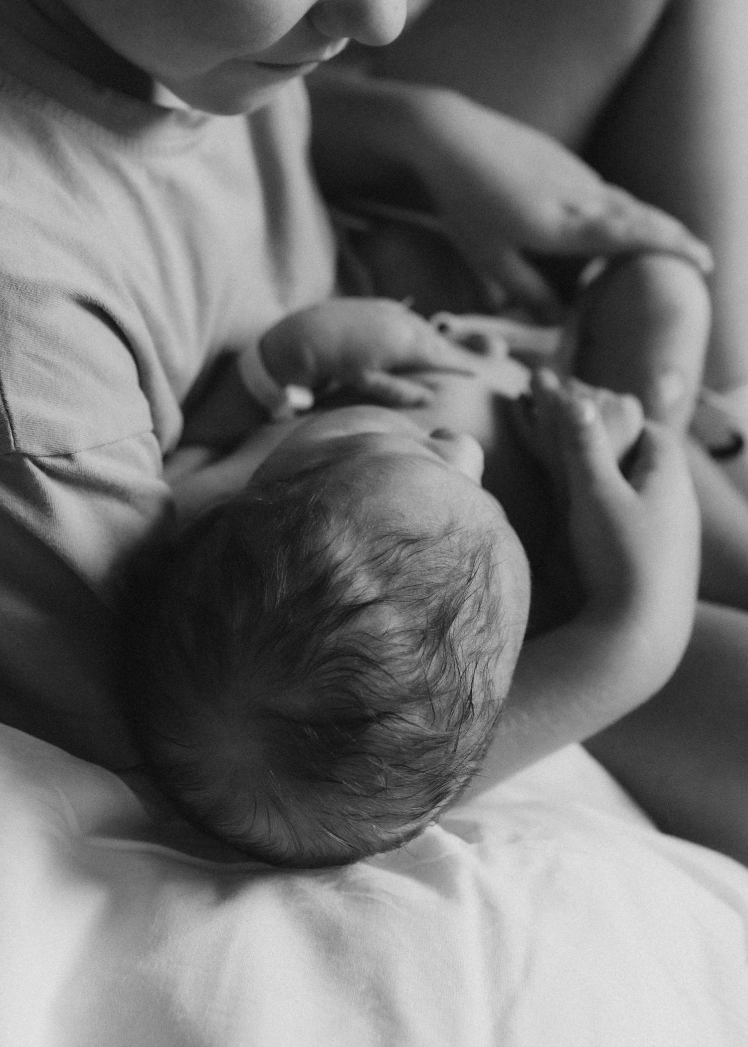 A series of monochrome close-up images showing a baby being fed from a bottle in different positions.