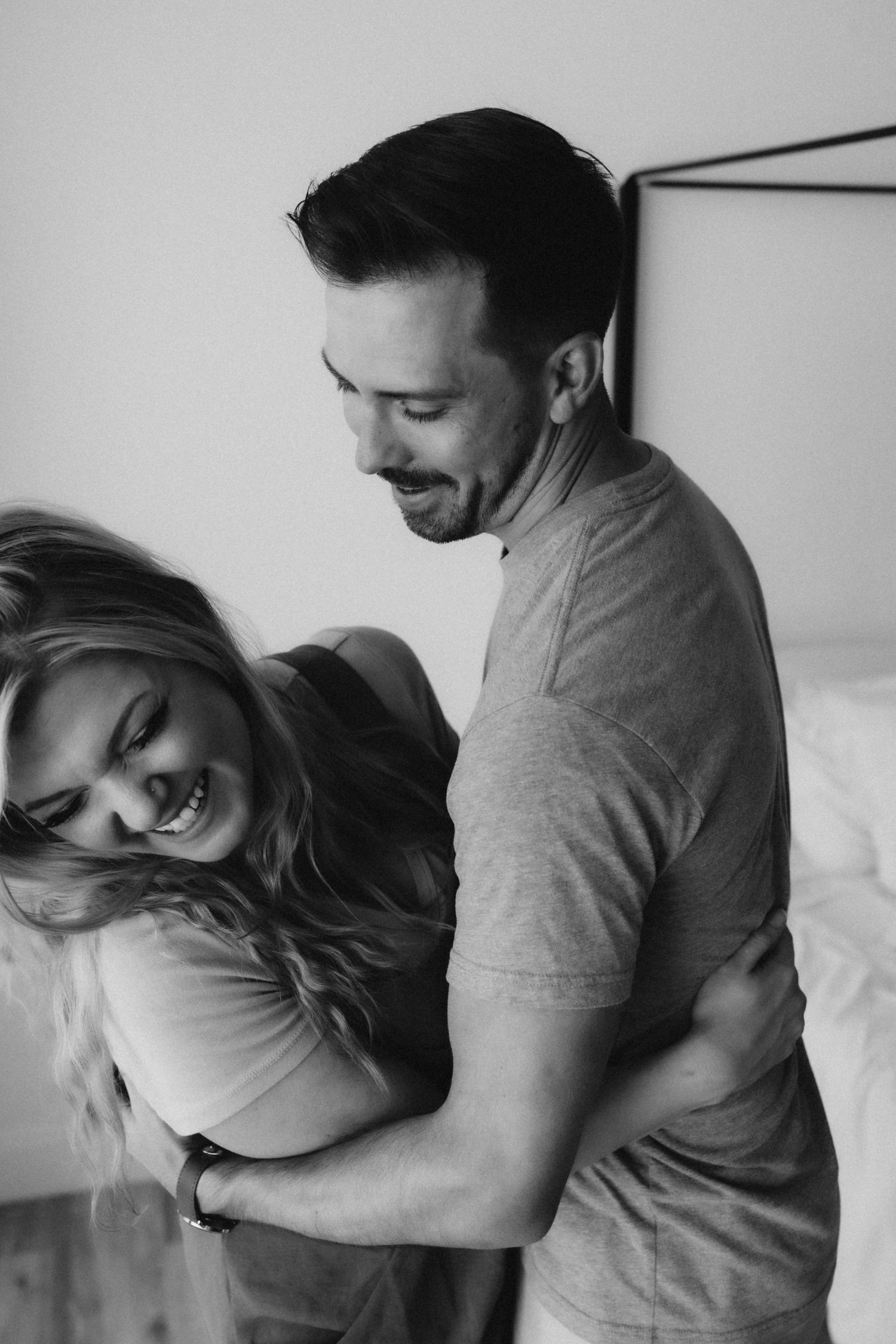Romantic black and white photo of couple embracing and laughing together.