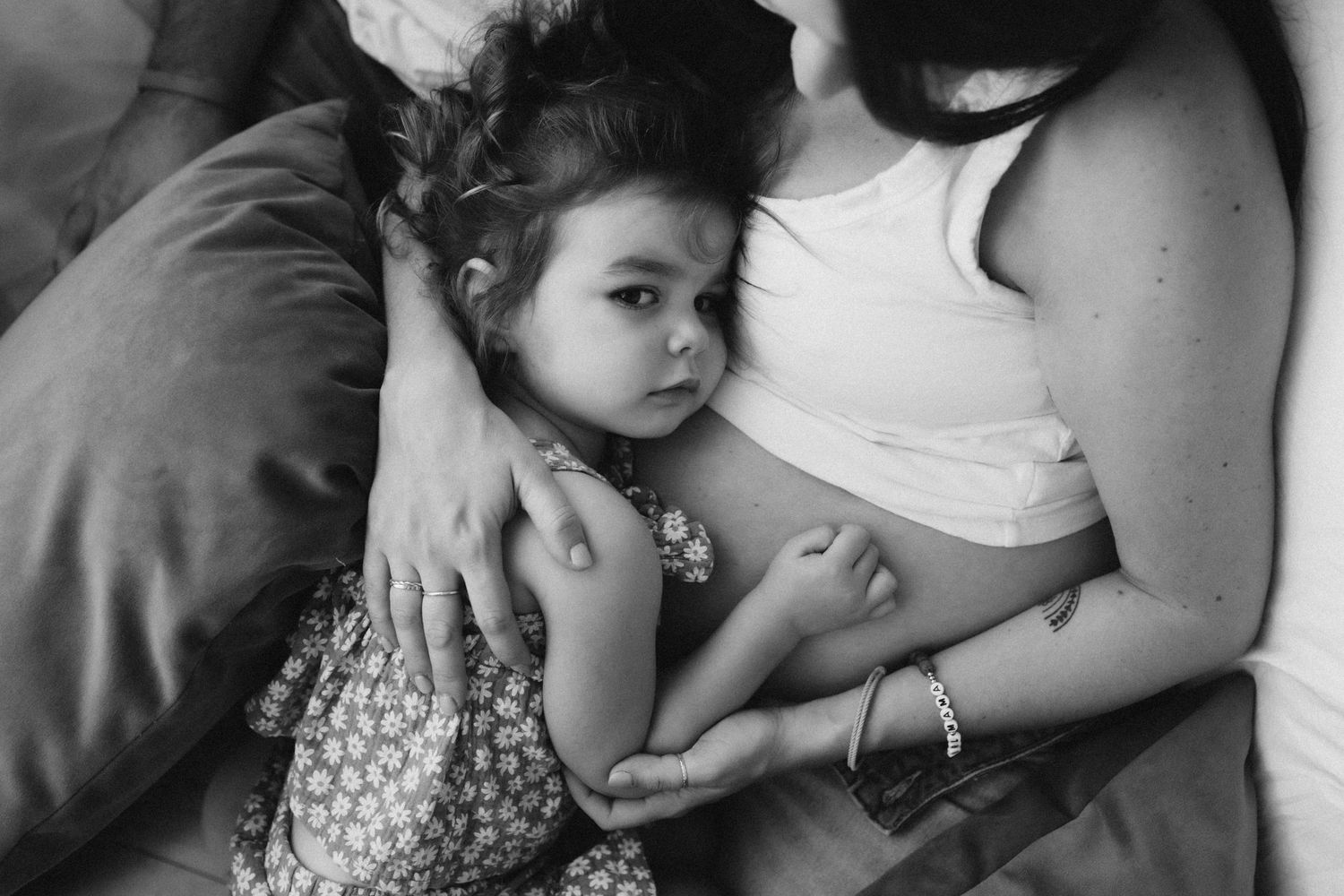 Intimate black and white family maternity moment showing tender connection.