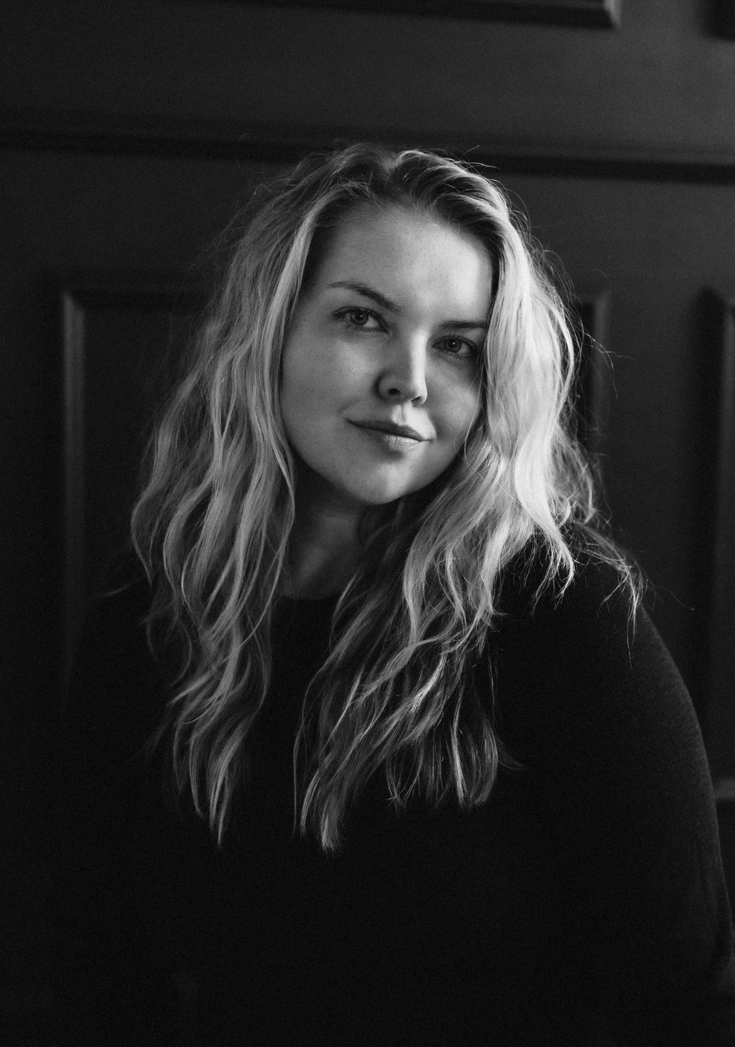 Black and white portrait with dramatic lighting and textured blonde waves.