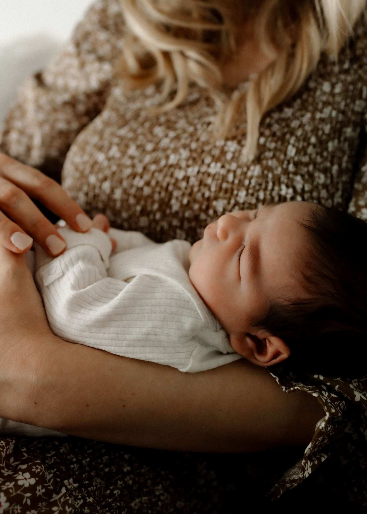 Peaceful newborn baby sleeping while resting on a cozy knit blanket.