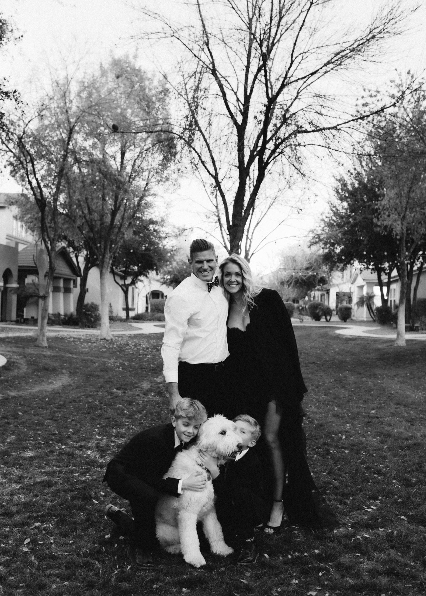 Black and white family portrait with children in a park setting.