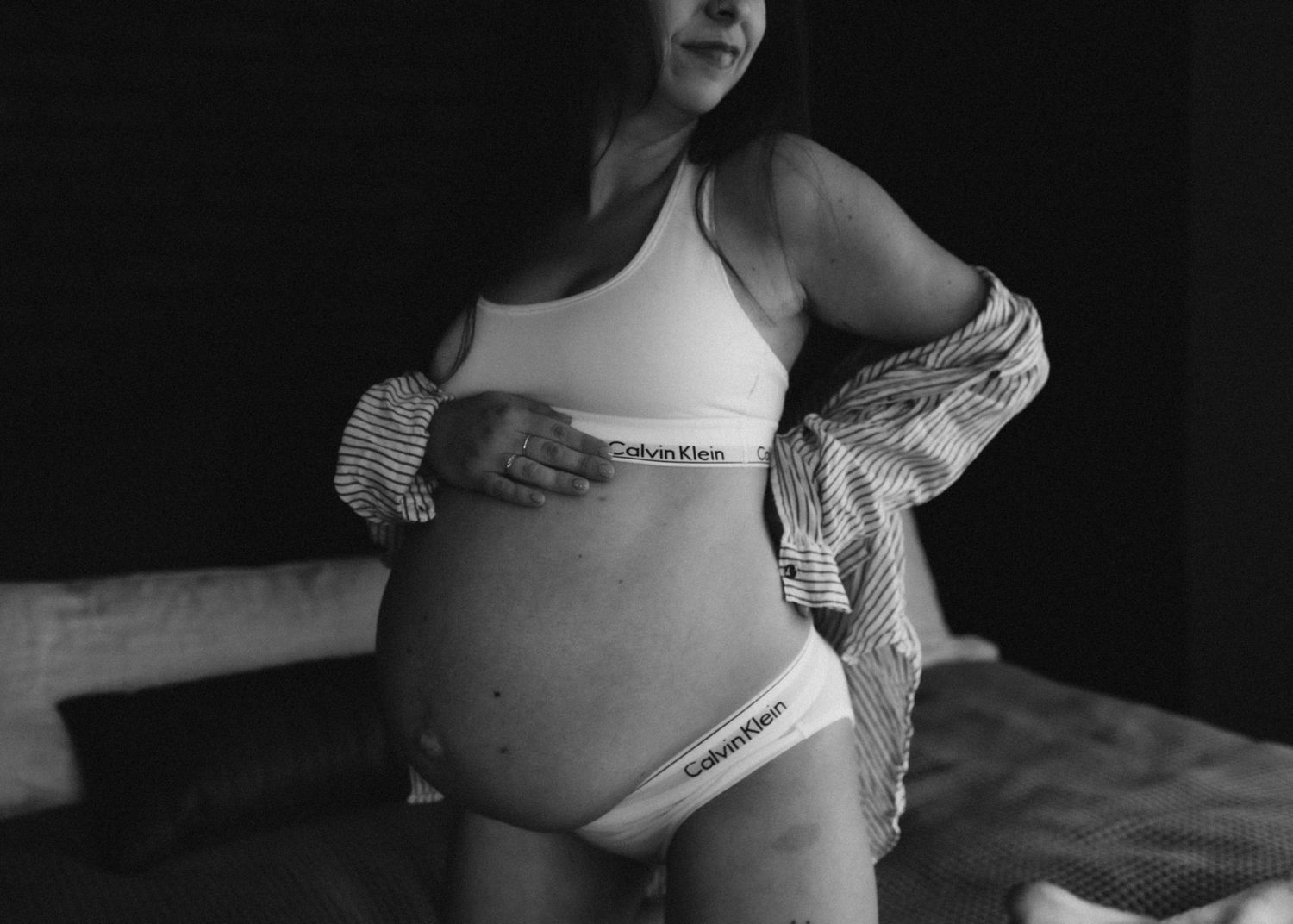 Artistic black and white maternity photo showing pregnant belly in Calvin Klein underwear.