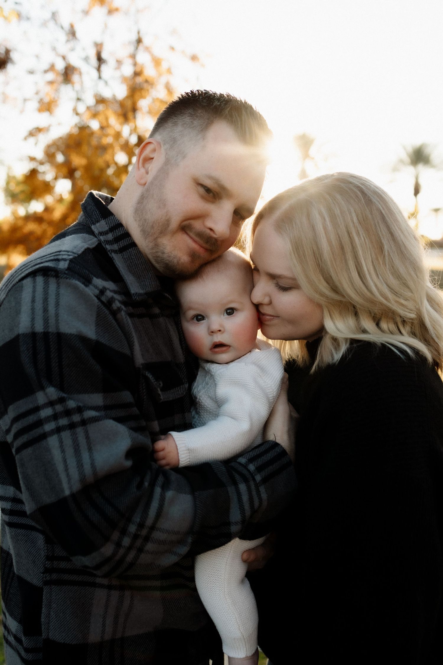 Intimate family portrait at golden hour with soft autumn lighting.