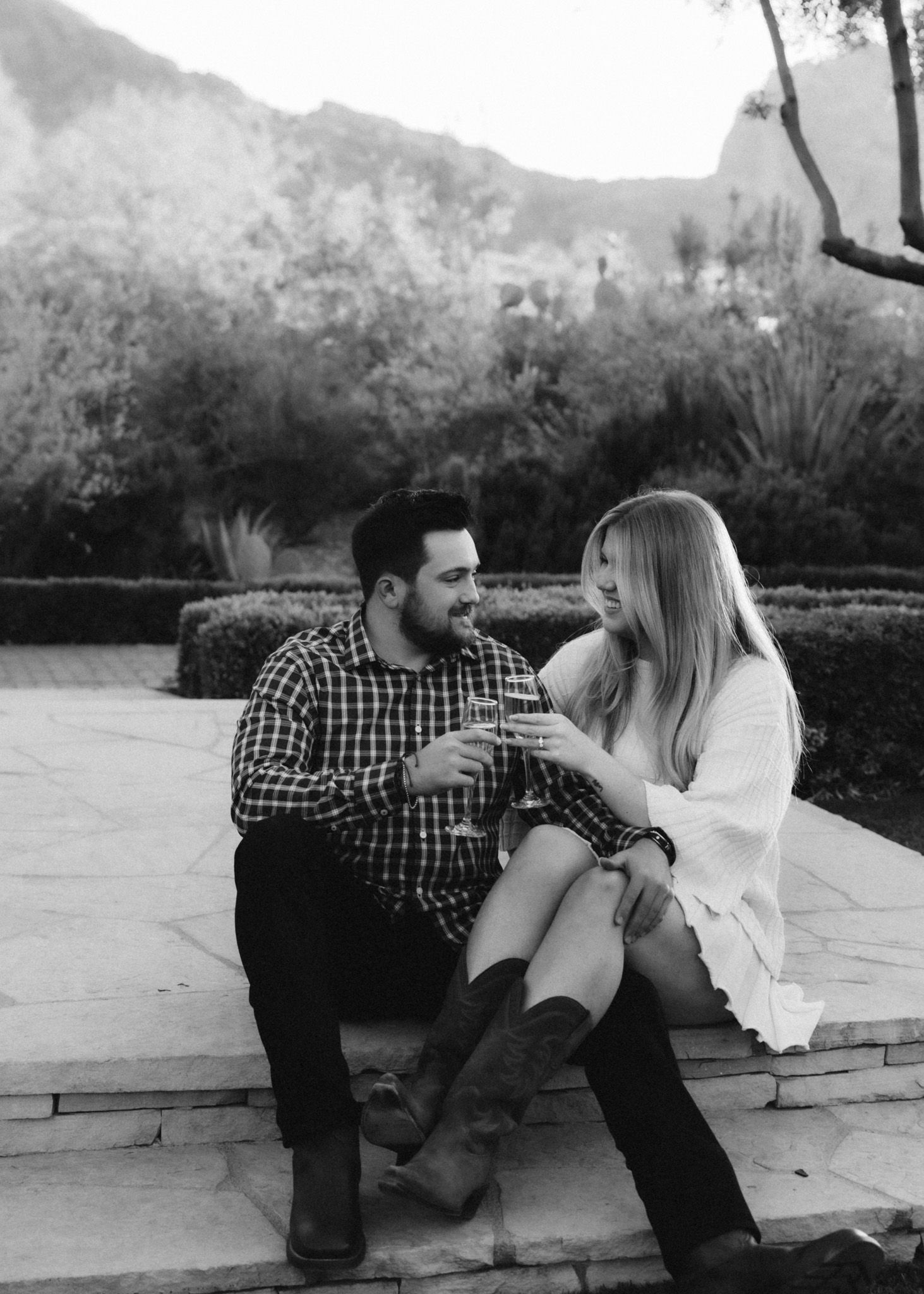 Romantic couple sitting outdoors sharing intimate moment on stone patio.