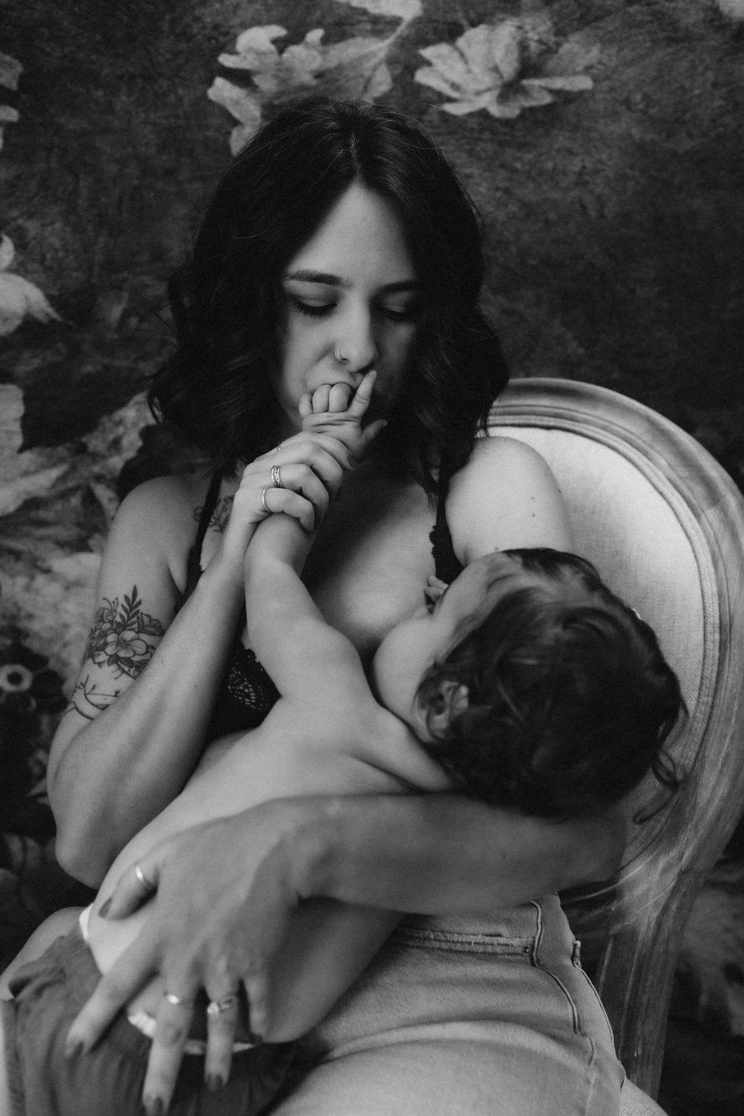 An intimate black and white portrait showing tender maternal bonding moments.