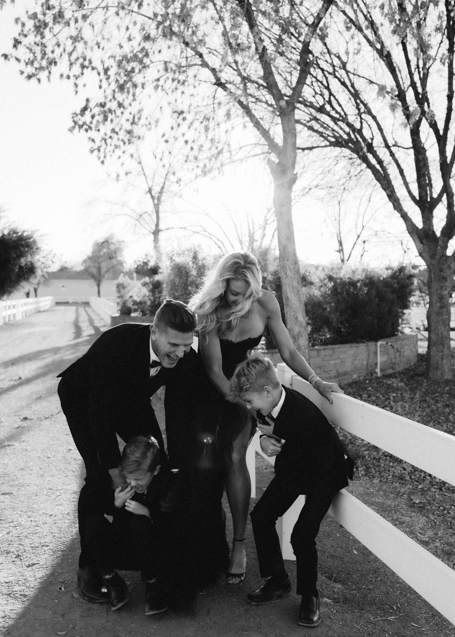 Candid family moment with children outdoors during a formal photo session.