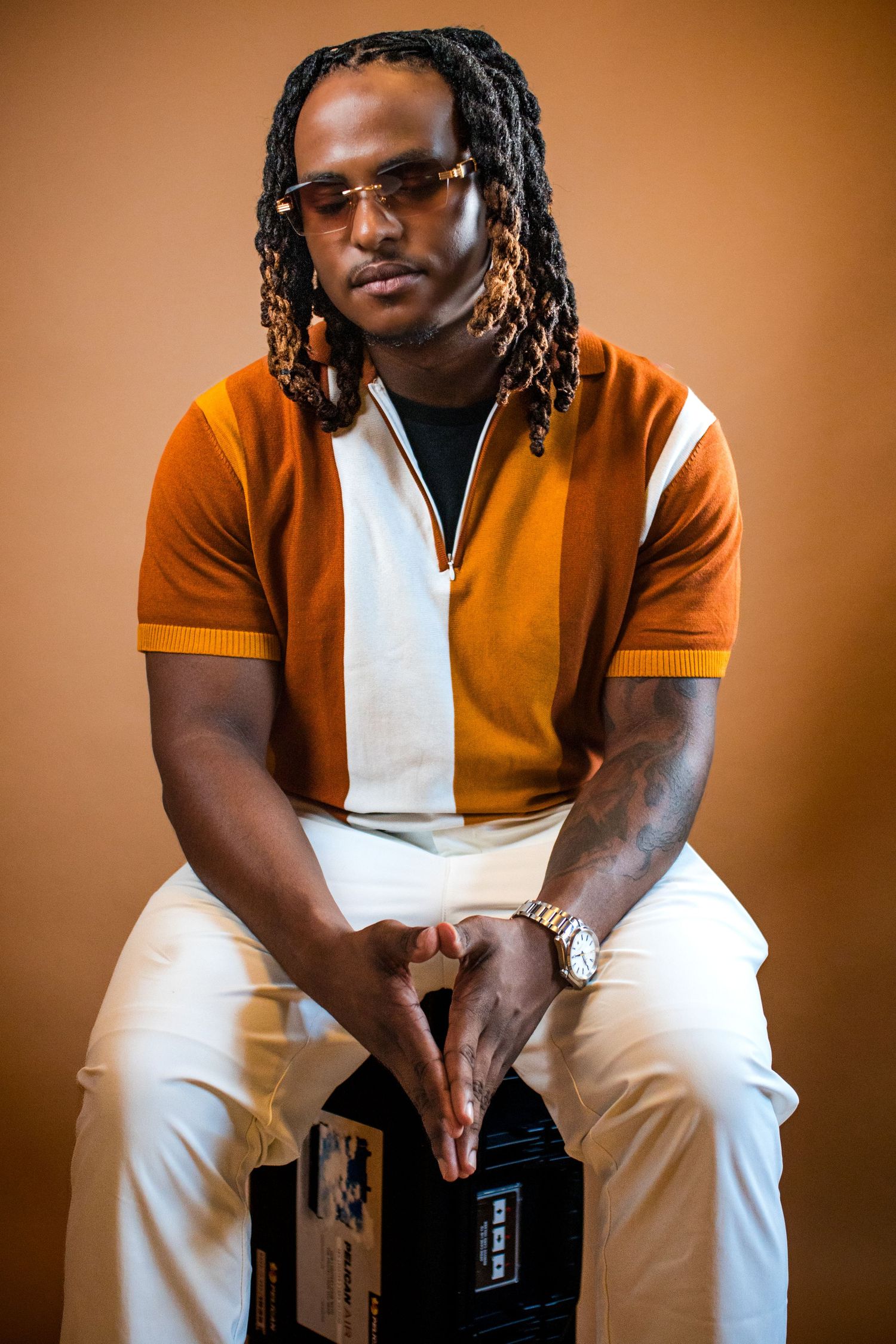 Professional studio portrait series in warm tones featuring person in orange and white outfit against brown backdrop.