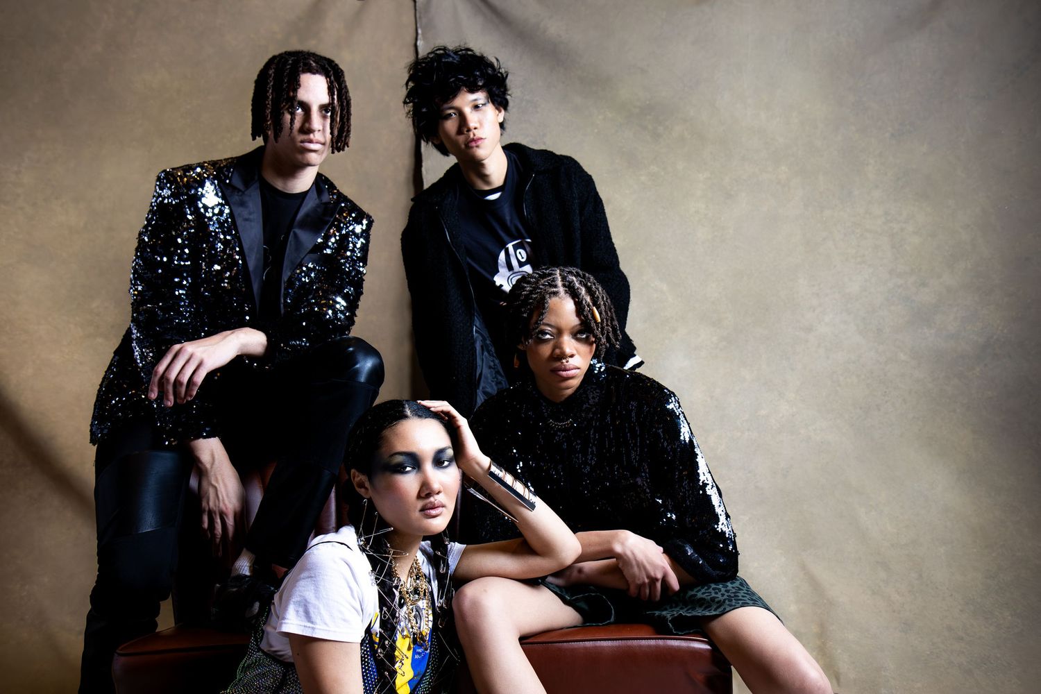 A group poses for a series of candid black and white studio portraits against a textured backdrop.