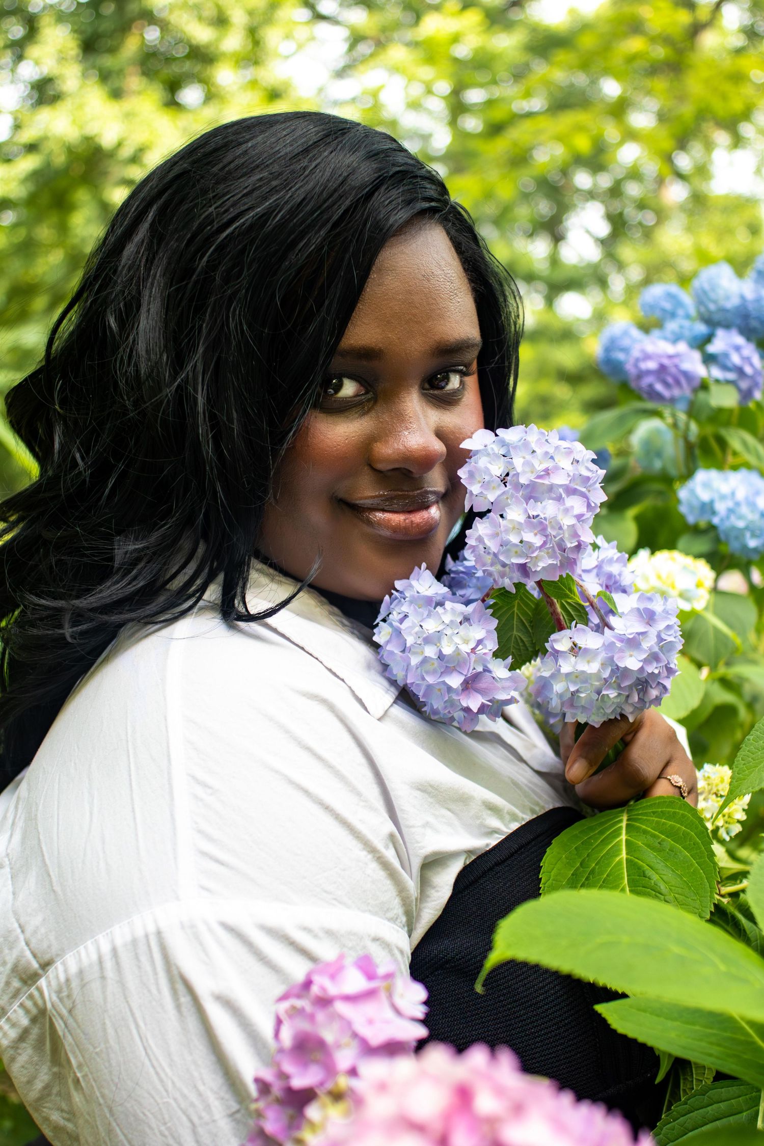 Sweet moment captured among purple and blue hydrangea blooms in a lush garden setting.