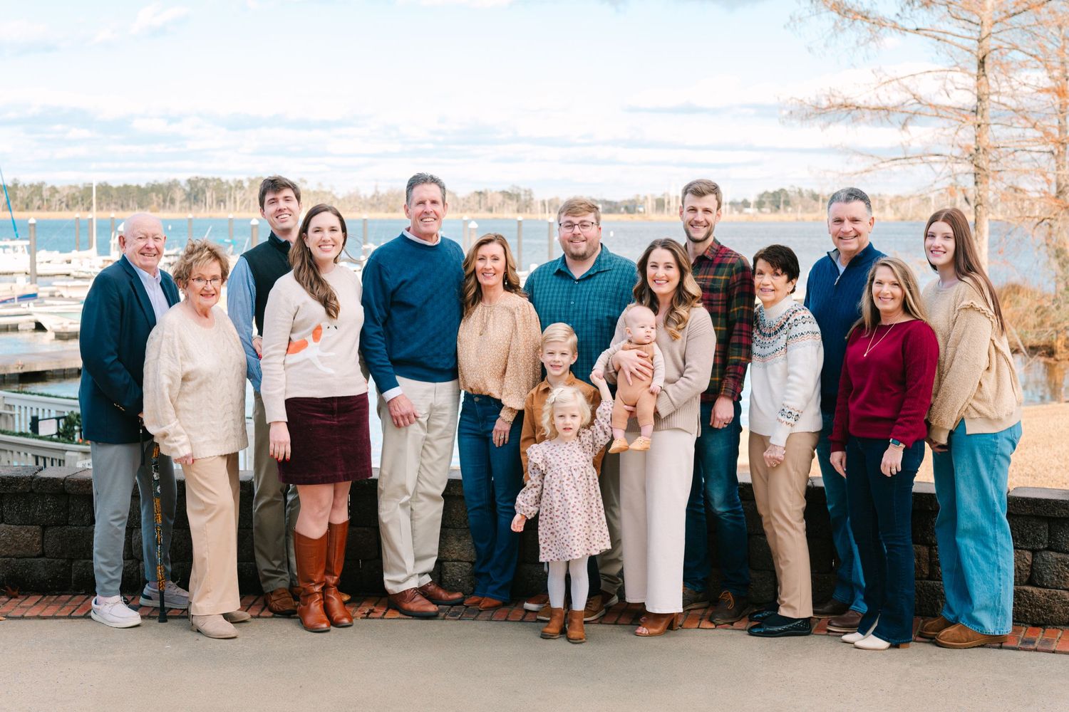 Large family group photo taken outdoors near waterfront.