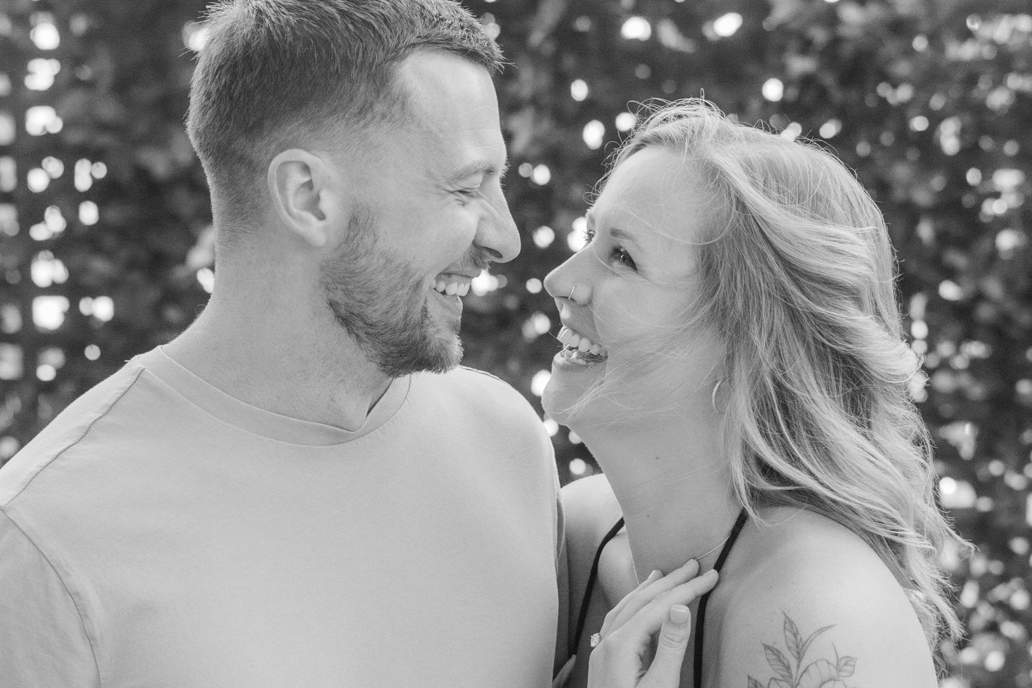 A tender black and white portrait of a couple sharing a joyful laugh together.