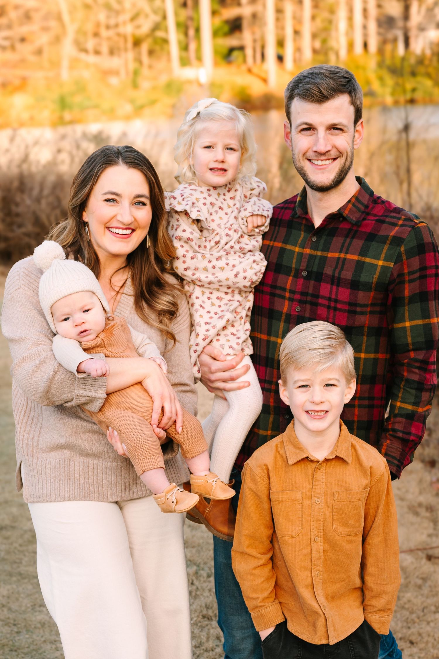 Happy family of five posing together for outdoor portrait during autumn.