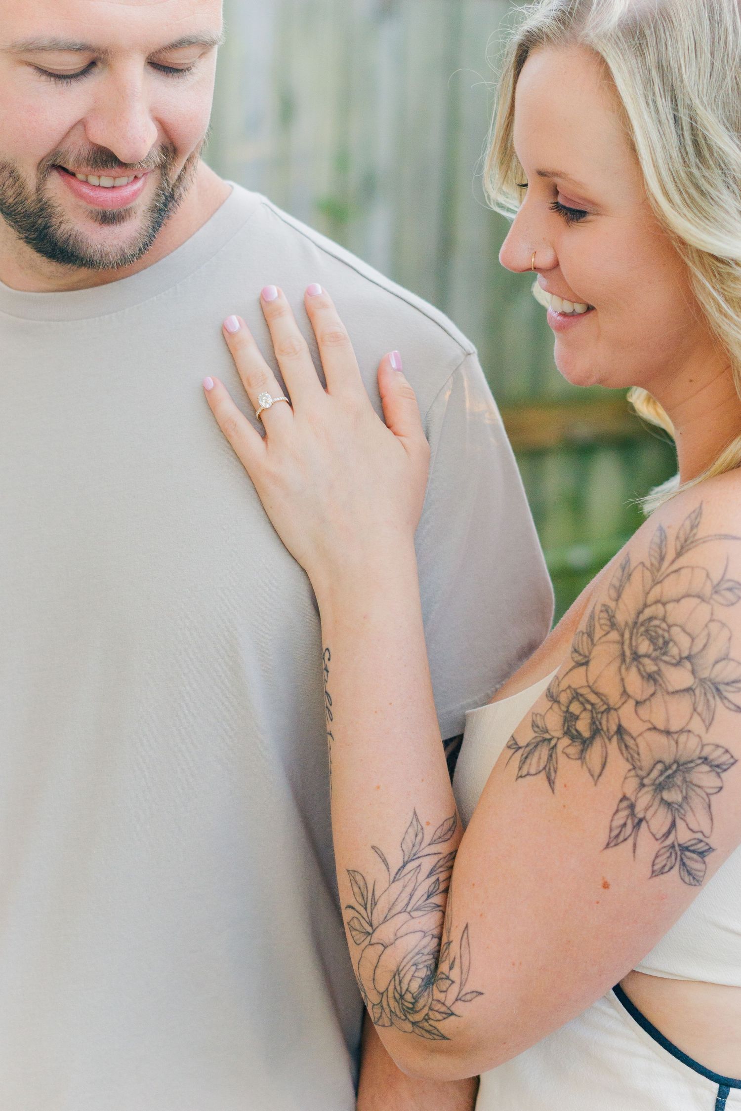 A sweet candid moment showing visible tattoo artwork and genuine smiles.