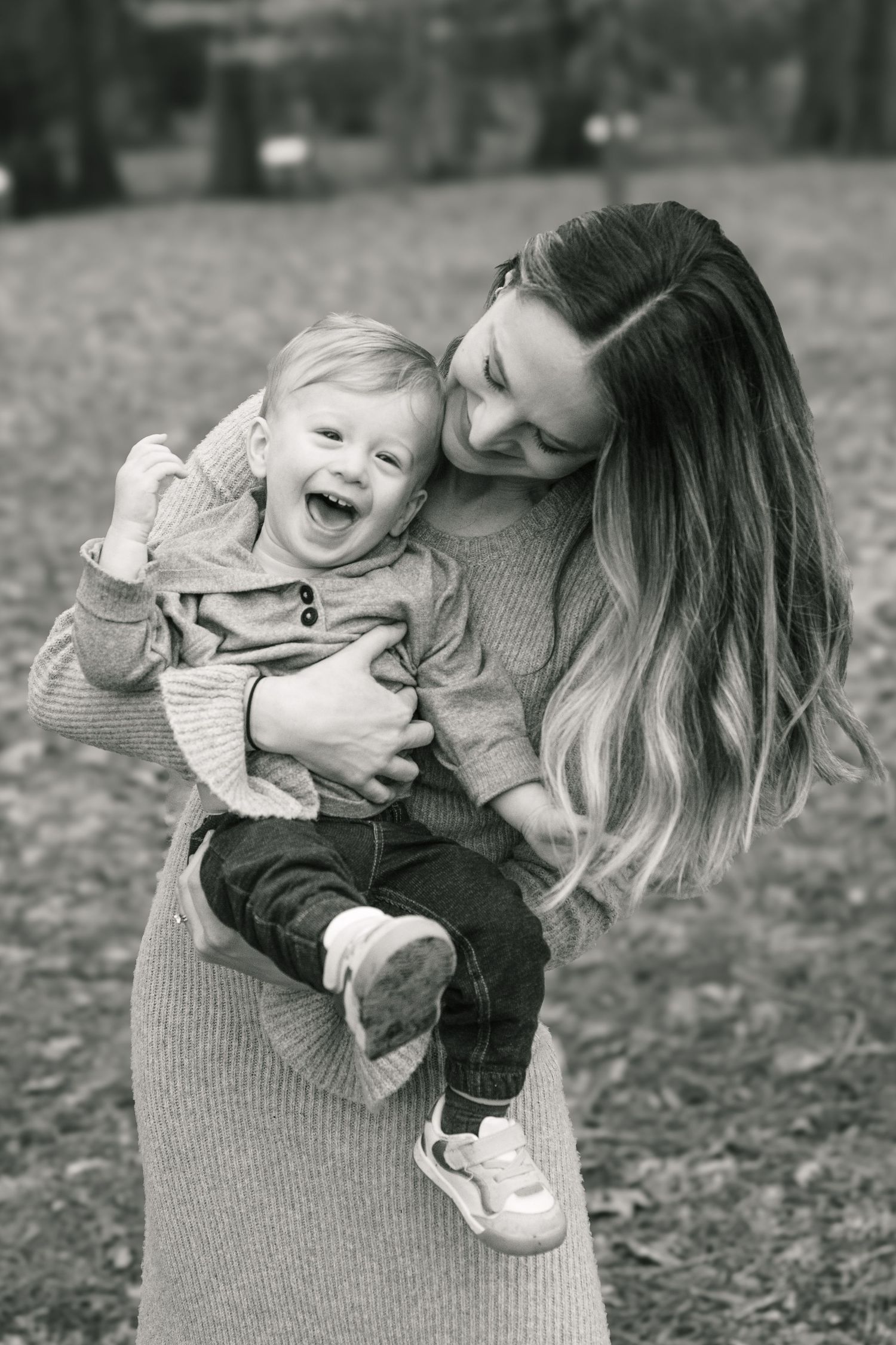 A tender black and white moment of laughter and bonding in a park with matching sweaters.